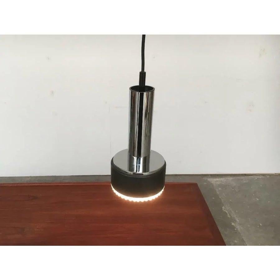Ciondolo p105 di metà secolo del noto produttore Staff Leuchten, Germania.

una forma semplice composta da diversi cilindri. Cromo nella parte superiore, marrone scuro o bronzo nella parte inferiore. Solo l'elemento di vetro più basso si illumina.