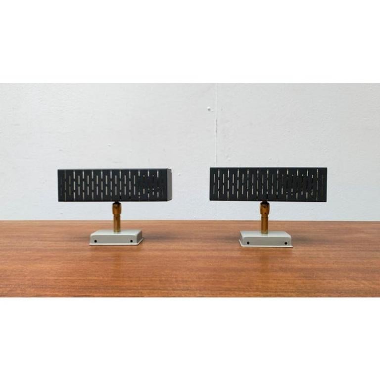Minimalistische Mid-Century-Wandleuchten von Leclaire & Schäfer.

Ein sehr geradliniges Design. Das quaderförmige Gehäuse ist aus schwarz oder dunkelgrau lackiertem Blech gefertigt. Als Diffusor wird eine lichtdurchlässige Acrylglasscheibe als