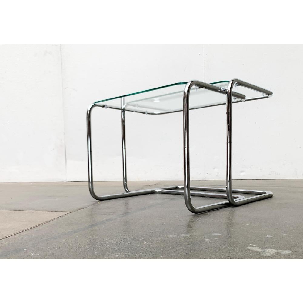 Elegantes tables d'appoint gigognes en tube d'acier avec plateau en verre.

Un design classique en tube d'acier chromé. Le tube du cadre est façonné en une boucle continue et forme un pied à la base et un cadre pour le plateau de la table. Les