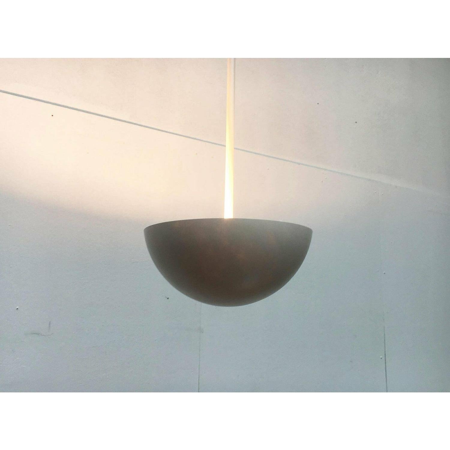 Eleganti lampade a sospensione a stelo con riflettori in fibra di vetro.

Un linguaggio di design minimalista con una combinazione di colori in bianco. Il dettaglio più sorprendente è il riflettore a forma di emisfero, che si trova alla base di