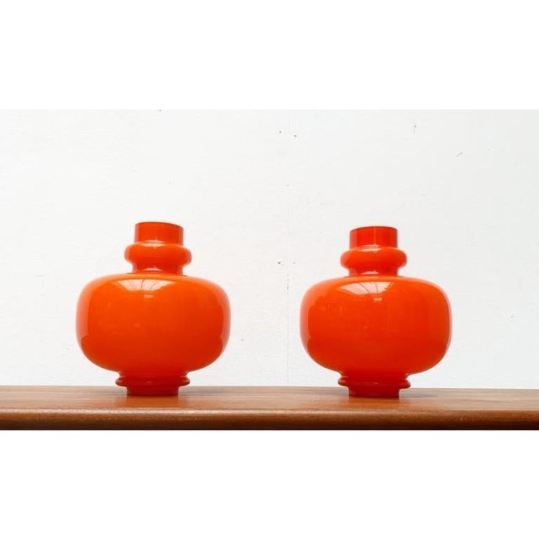Lampade a sospensione ornamentali in vetro su disegno di Hans-Agne Jakobsson.

Il diffusore serve un bicchiere di vetro con un'oliatura e una curvatura particolari. I corpi in vetro bianco arancione si capovolgono e dispiegano il loro effetto sia in