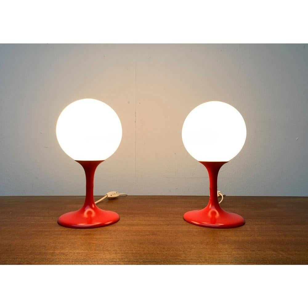 Deux lampes de table du fabricant suisse Temde d'après un design de E. R. Nele.

Des lampes de table simples dans une couleur frappante. Une boule en verre opale repose sur un pied en forme de trompette élégamment incurvé. Le pied est dessiné en