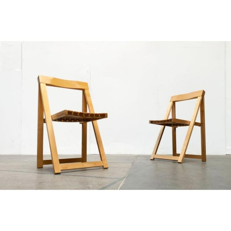 Dos sillas plegables Trieste de mediados de siglo según un diseño de Aldo Jacober.

Sillas plegables sencillas de madera. El diseño convence por su forma clara y su construcción sencilla. El respaldo es el elemento más ejecutado de la silla. Está