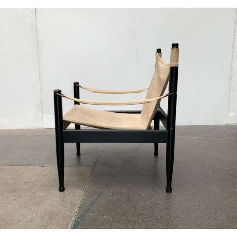 Sedia Safari di metà secolo del produttore danese Niels Eilersen dopo un progetto di Erik Wørts.

Questa versione colpisce per la sua colorazione. La struttura è di colore nero e crea un forte contrasto con il tessuto chiaro della seduta. Le cinghie