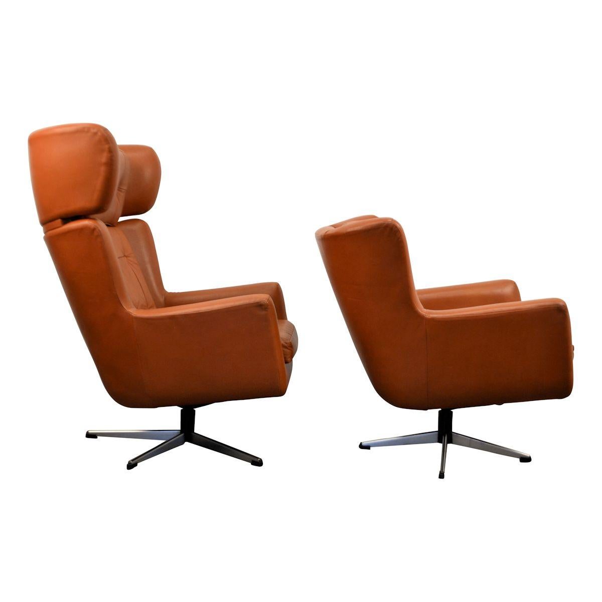 Set of two Danish modern leather lounge chairs designed and manufactured by Skjold Sørensen, Denmark. These brown leather swivel chairs on a steel frame feature a typical vintage design, offer a great level of comfort and padded backrests. The set