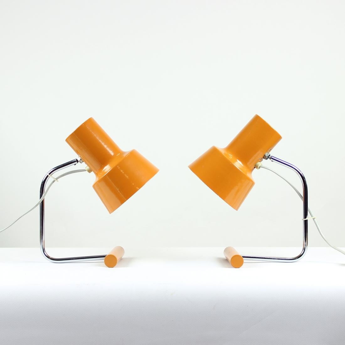 Set of two beautiful table lamps by Lidokov company, designed by Josef Hurka. Produced in 1960s, the lamps are iconic work of the designer. The chrome construction connects the metal base and shield in orange color. The lamps are in original color