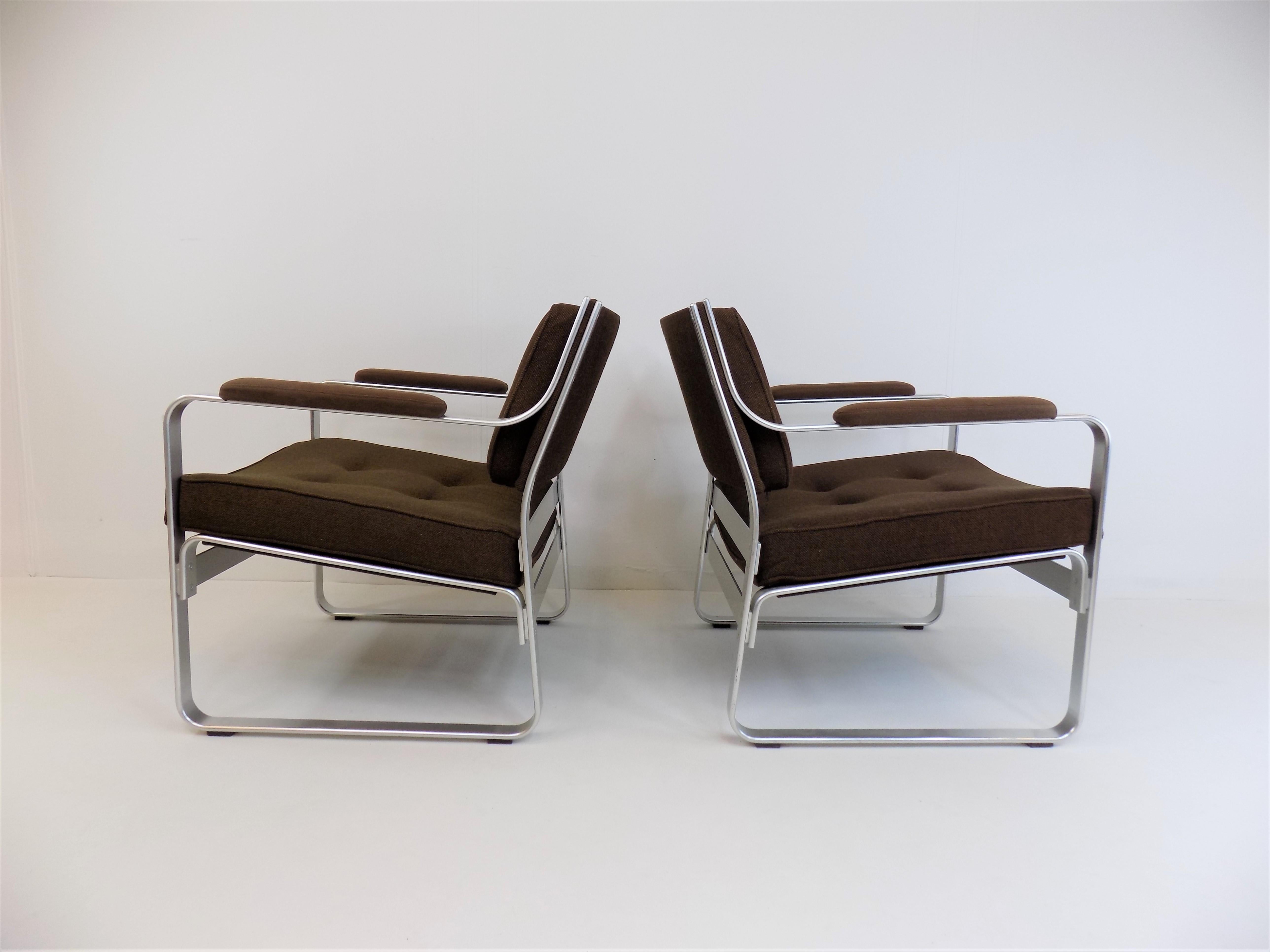 The two Mondo armchairs in the wider and deeper lounge chair versions are in excellent, almost new condition. The brown fabric cover of the armchair shows almost no signs of wear, the aluminum frames are immaculate. These armchairs are characterized