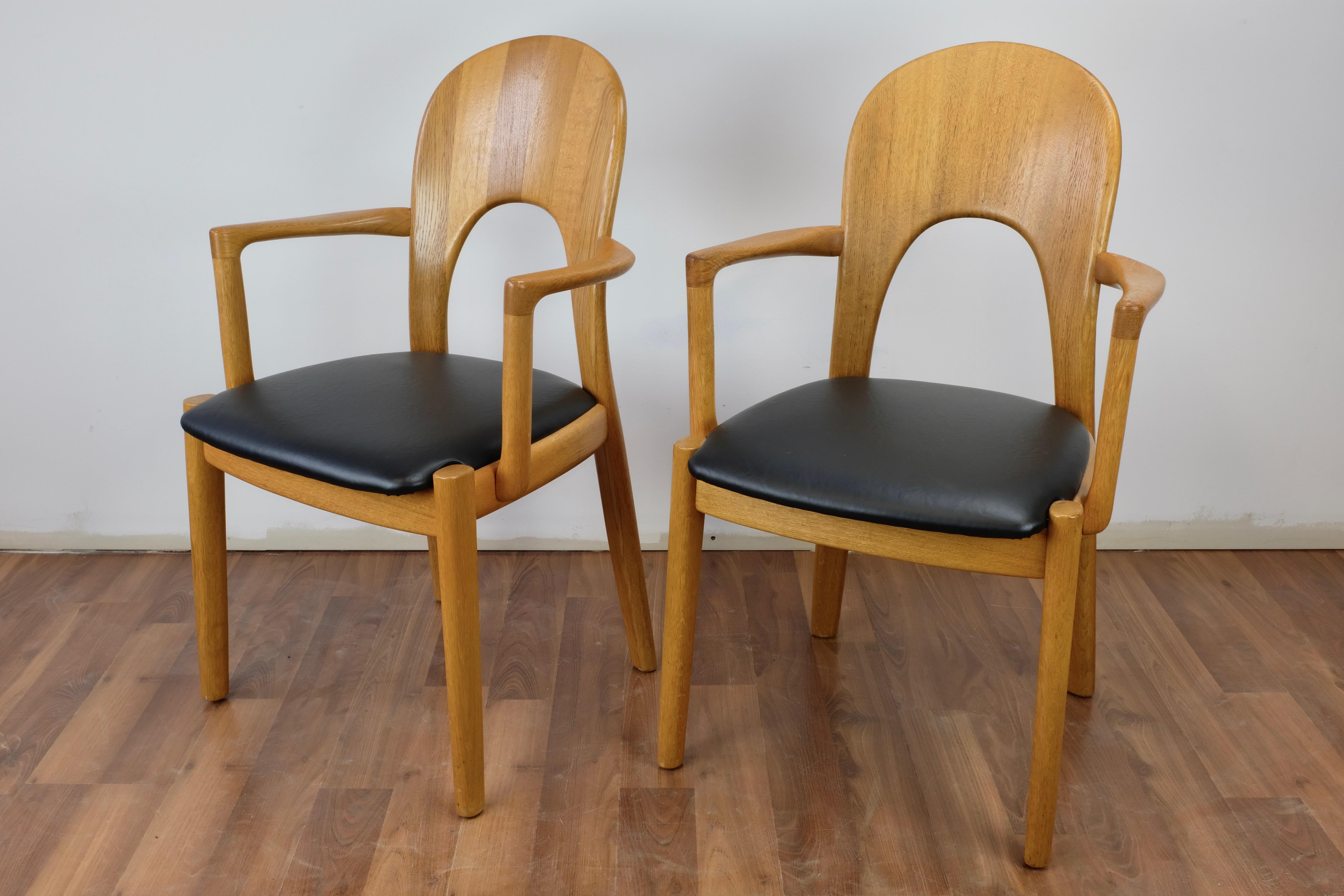 Set of 2 Morten armchairs in oak designed by John Mortensen and made in Denmark by Koefoed.

The chairs are in excellent condition with new black leatherette upholstery.