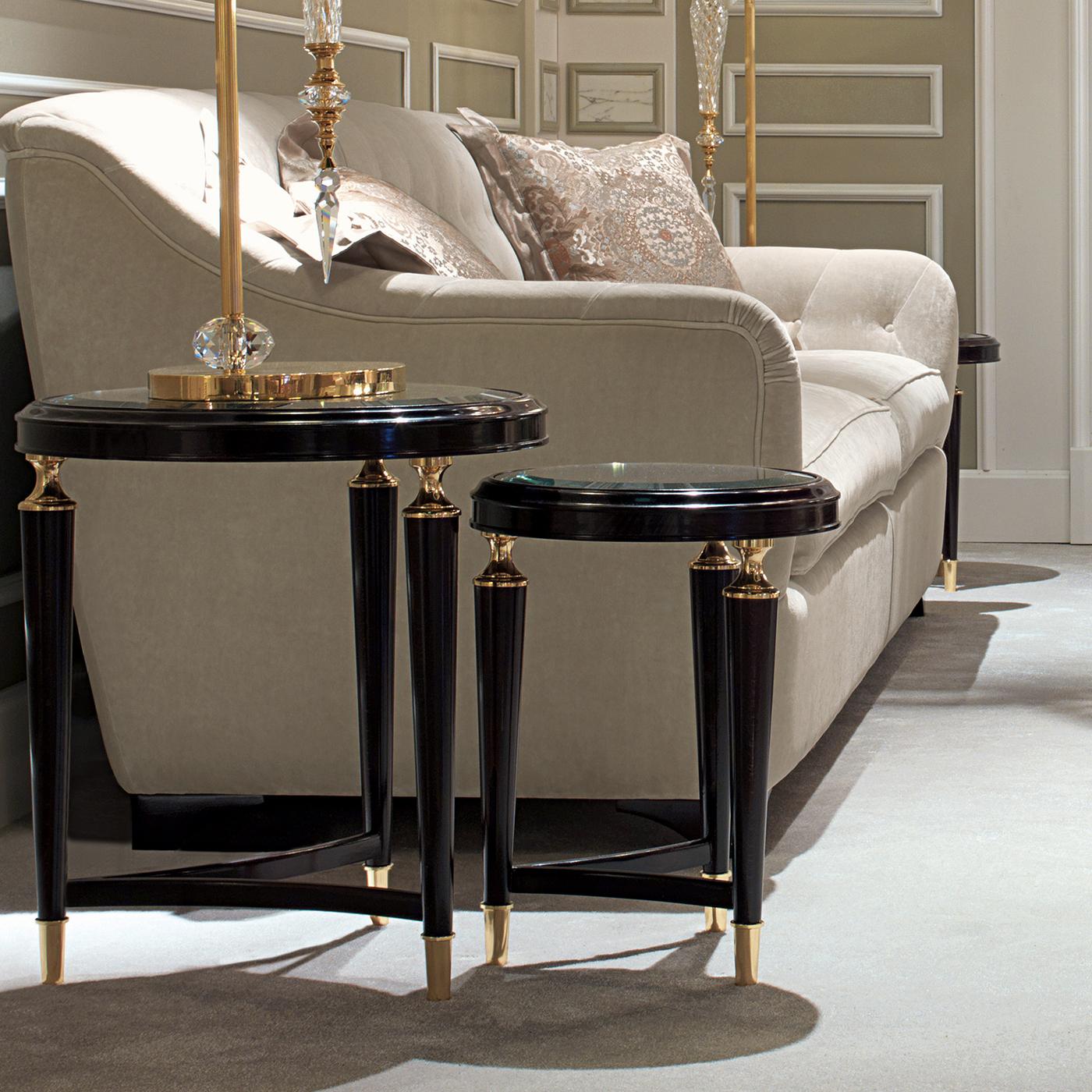 This charming set of two nesting side tables is a precious and versatile addition to a Classic decor. Either together, as pair, or displayed separately, this duo will add elegance and a retro allure to a living room. The structure of each piece is