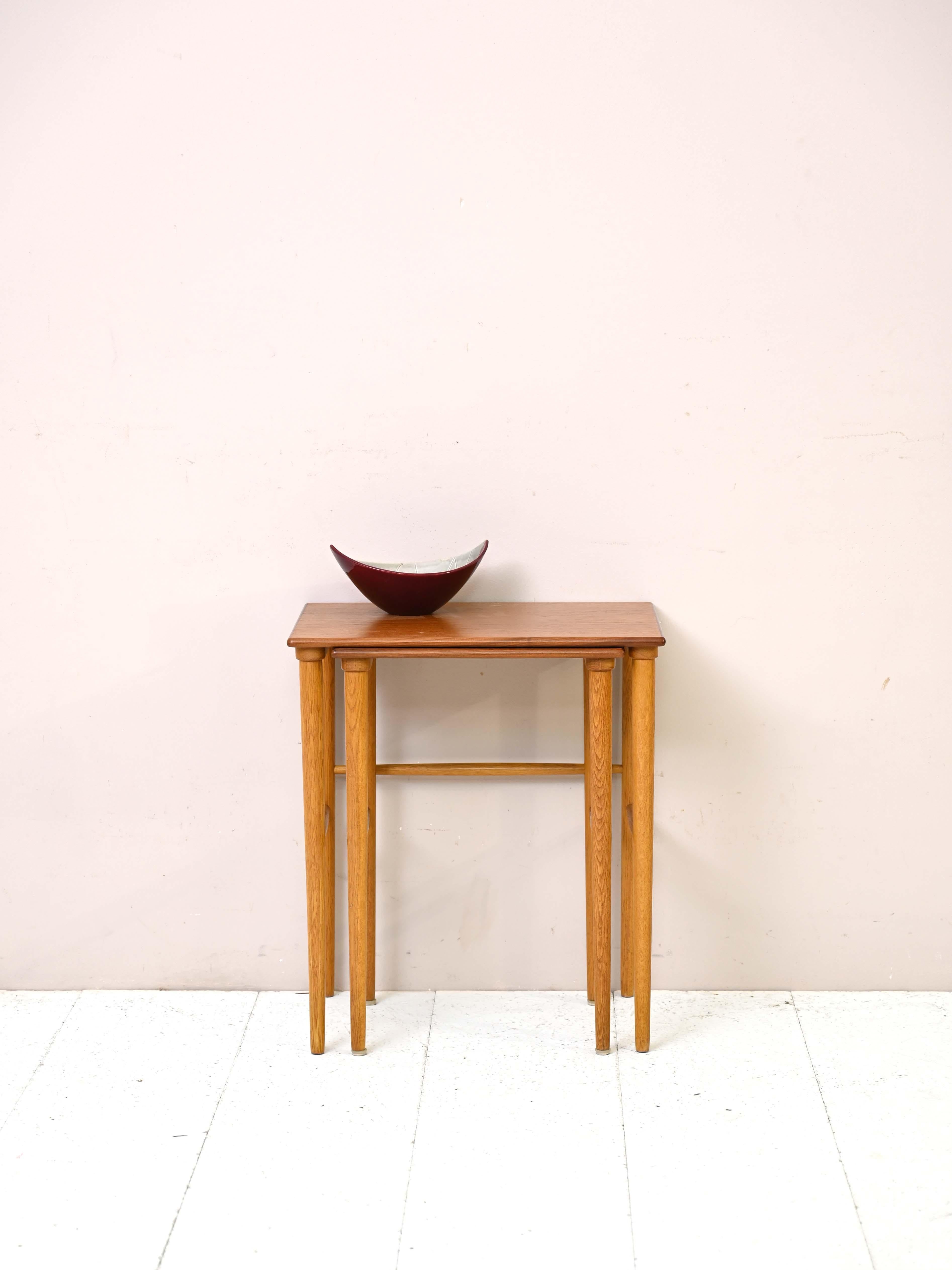 Vintage Scandinavian side tables.

These two small coffee tables are ideal for those who have limited space in the home but do not want to give up a practical and visually pleasing tabletop.
Consisting of a simple square teak top and long tapered