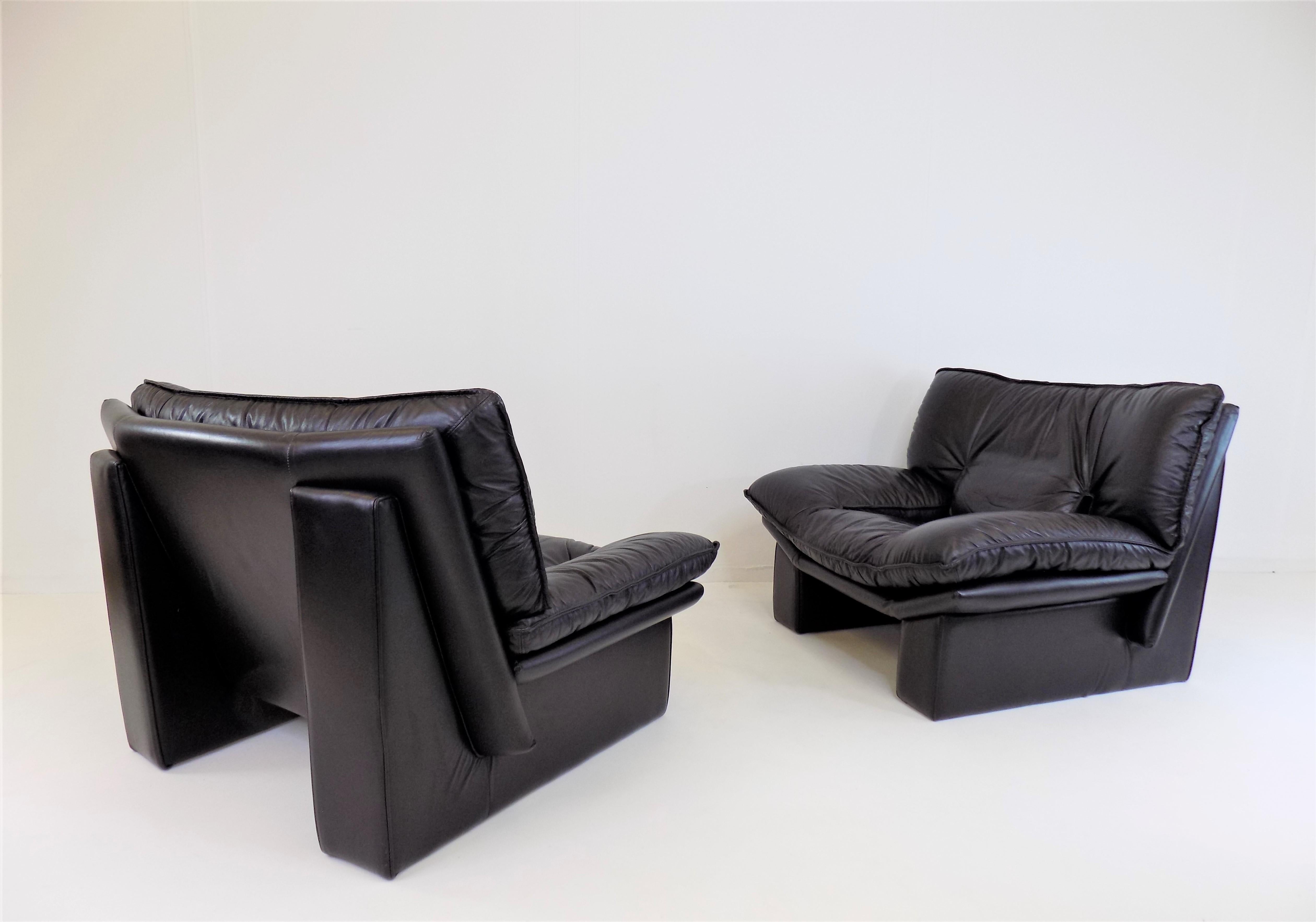 These two Ambassador leather armchairs are in excellent condition. The soft black leather is immaculate and shows minimal signs of wear. The armchairs are characterized by the solid-looking pillars on the back of the armchairs, which give them a