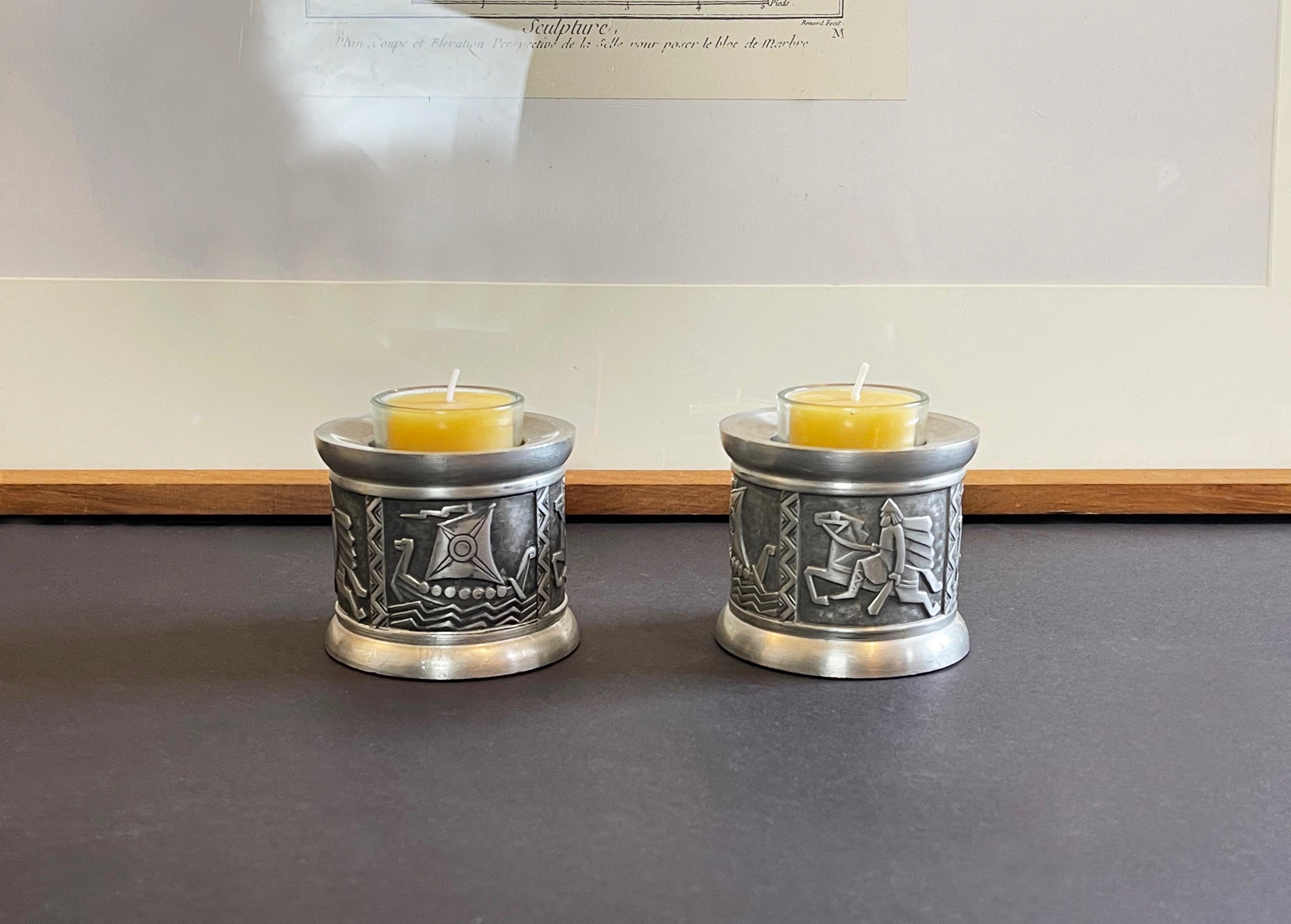 Norwegian mid-century modern candleholders by Mastad Pewter, Norway.

Wonderful Scandinavian design with blackened relief of wild horseman and a typical Viking ship set sail.
Made beautifully from pewter, made to fit 1 tea light candle each.
Solid