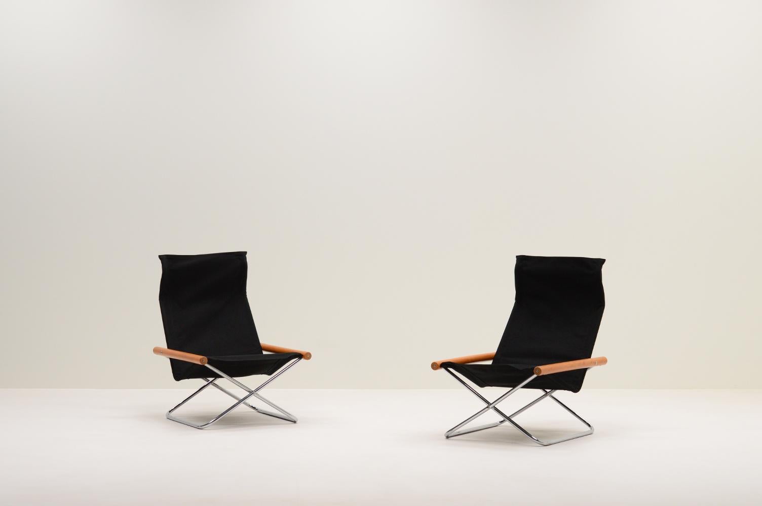 Ensemble de 2 chaises NY par Takeshi Nii, 1950s Japon. Chaises pliantes minimalistes avec une base en X chromée, des accoudoirs en bois de hêtre et une assise en toile noire retapissée.  La chaise a été baptisée MEAN, d'après le nom de famille du