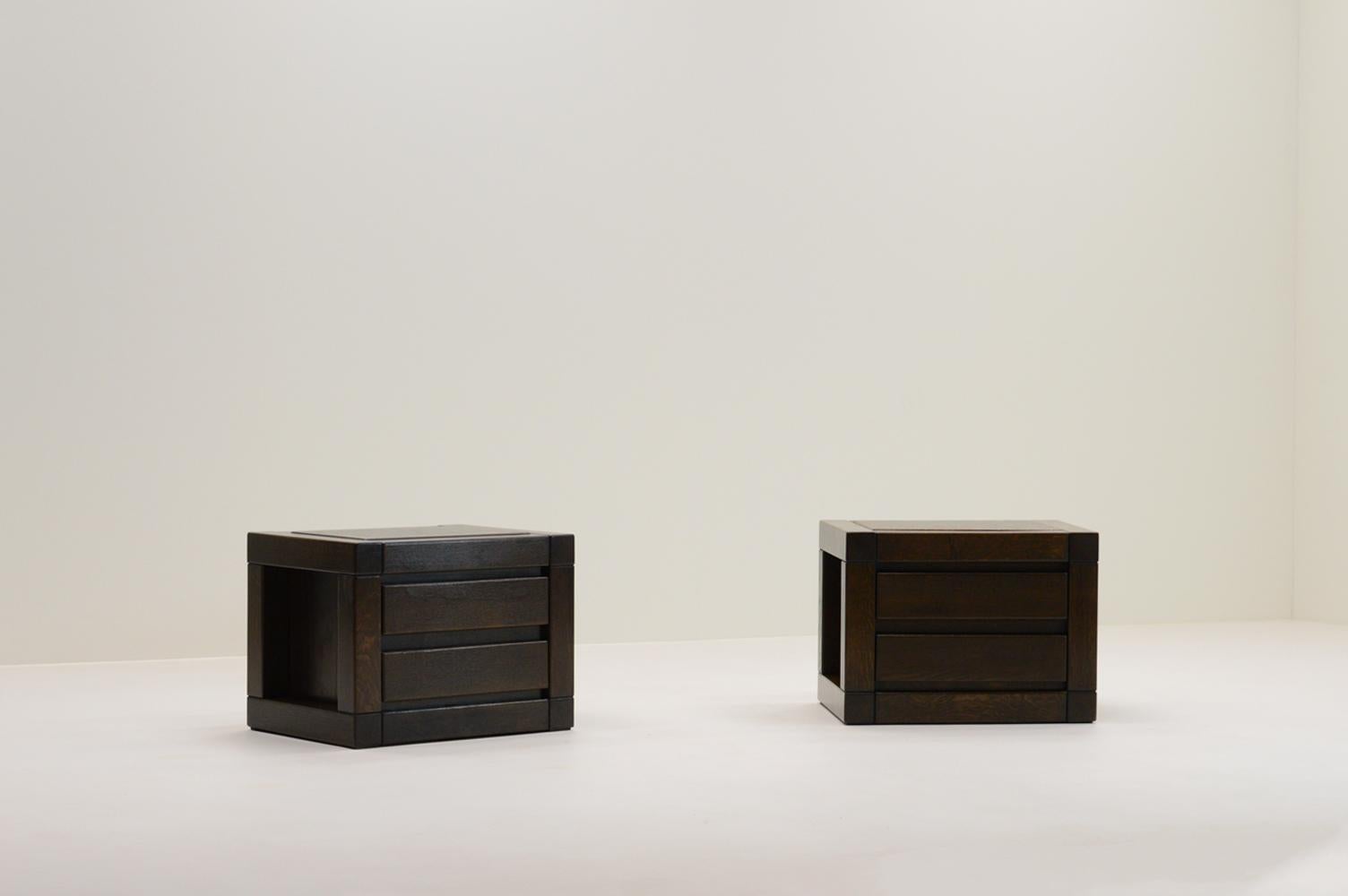Set of 2 oak bedside drawer cabinets, 1970s Europe. This set is made of solid dark stained oak. A minimalistic brutalist design. Each cabinet has two drawers. Could also function as side tables. In good vintage condition. 

Request a quote for the