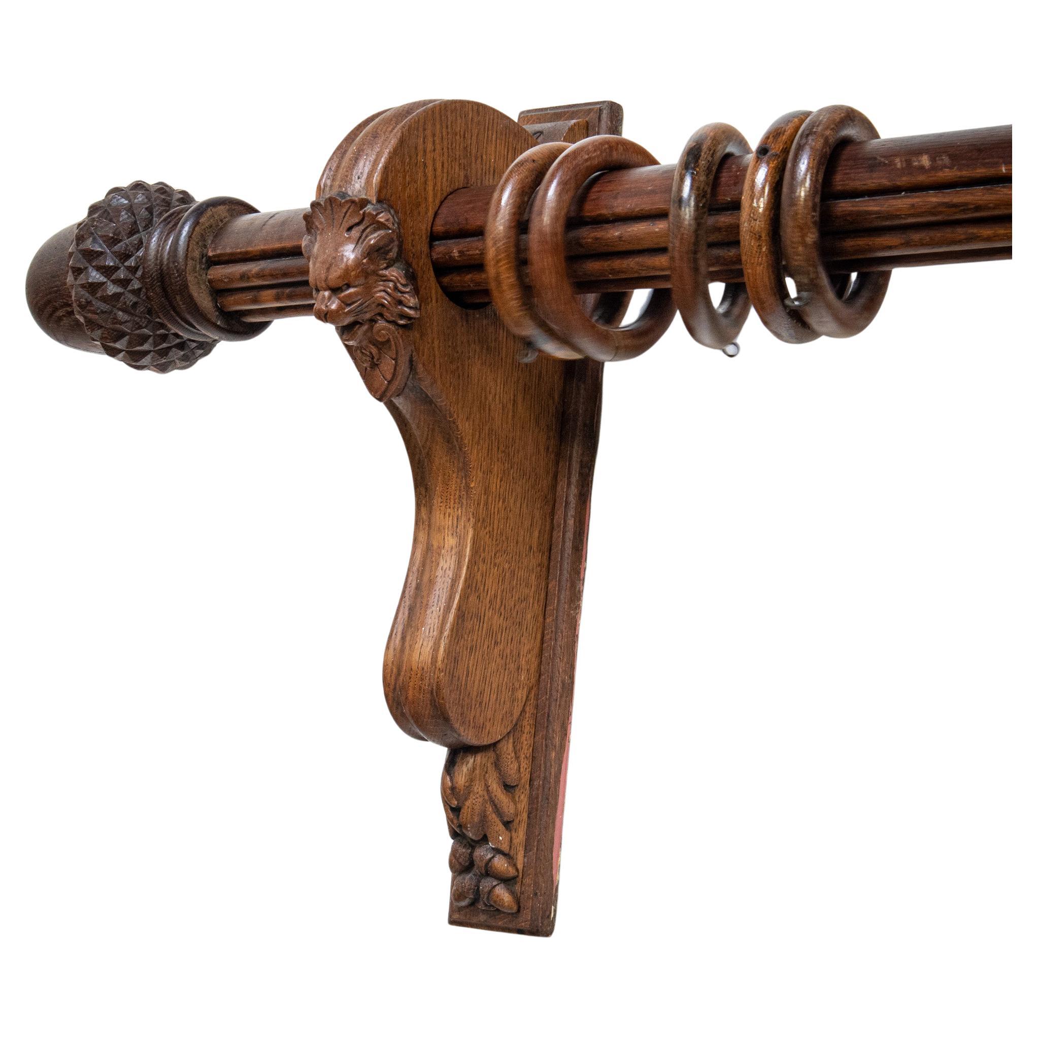 A magnificent pair of early 20th century oak curtain poles with all fittings. Each of the substantial reeded oak poles has a pair of impressively carved scrolling oak wall brackets that carry the poles. The brackets are decorated with applied