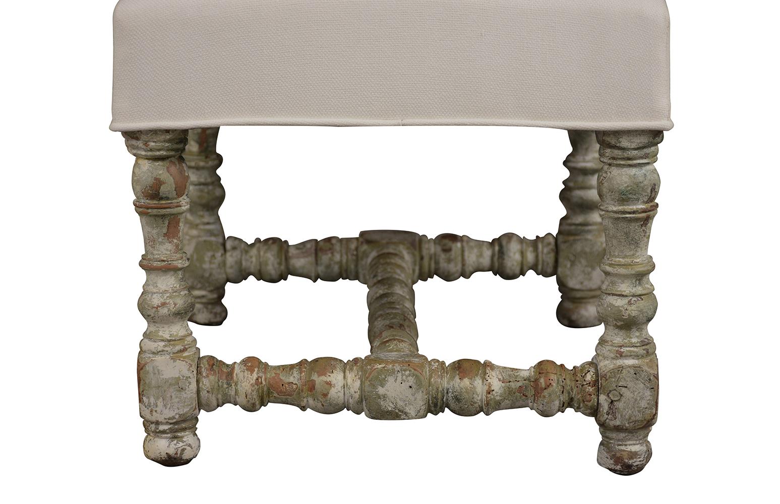 This 1860s antique carved foot stools are in remarkable condition. The carved wood frame is finished in a pale grey and off-white color combination with a distressed finish. The seat has recently been professionally upholstered in an off white