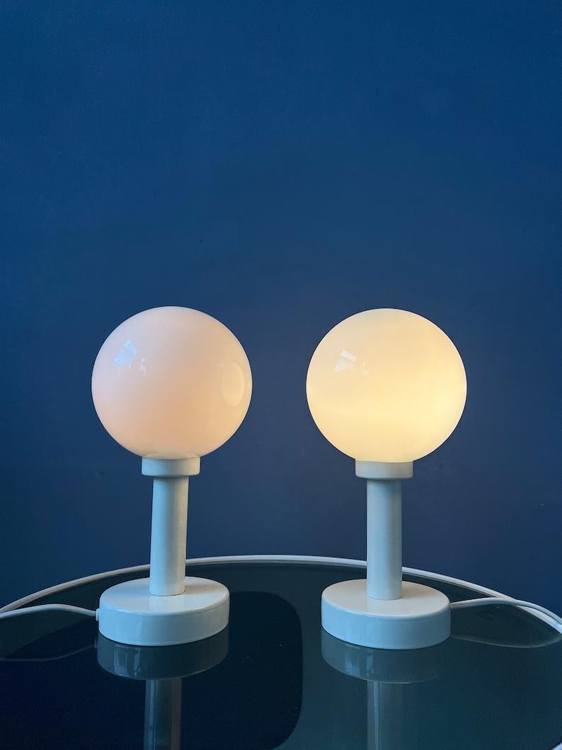 Set (2) of mid century table or bedside lamps with opaline glass shades. The bases are made out of wood and have a black and grey lacquer. The lamps require E14 lightbulbs and currently have EU-plugs.

Additional information:
Materials: Glass,