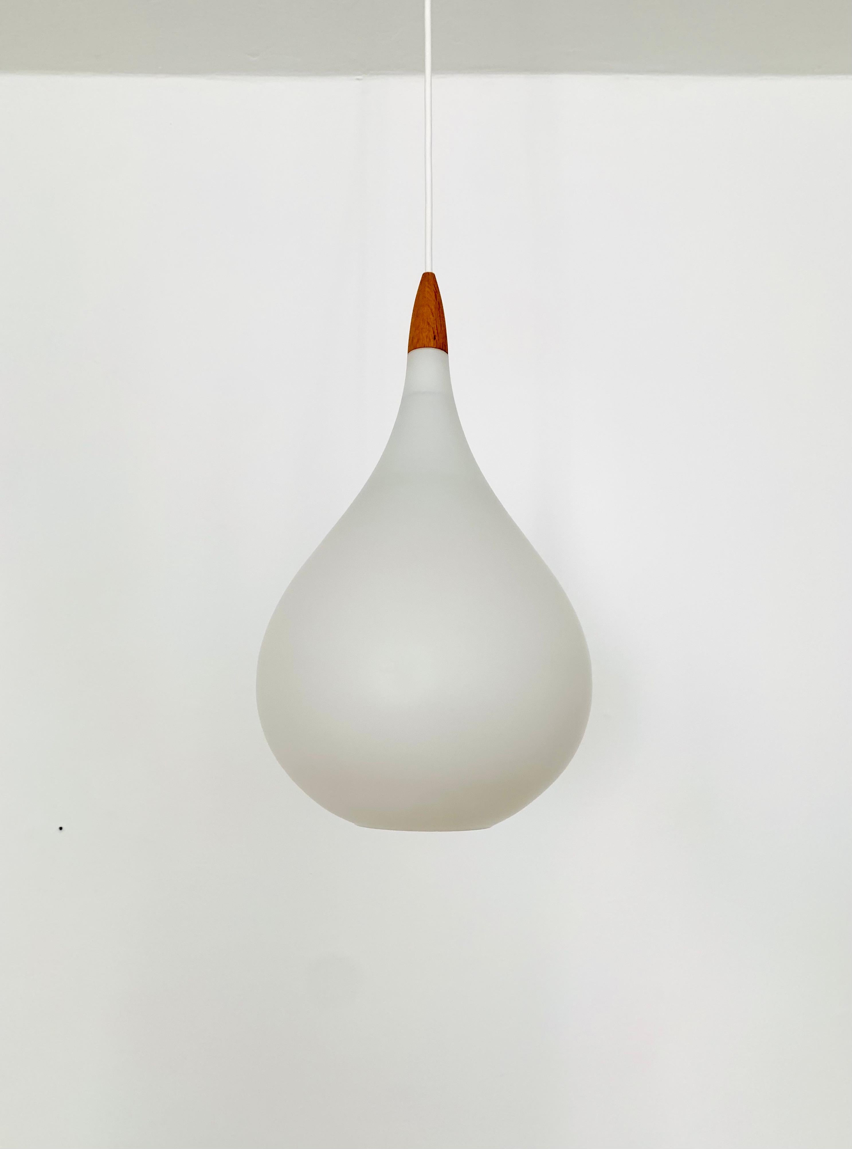 Wonderful Swedish opal glass pendant lamps from the 1960s.
Great and exceptionally minimalist design with a fantastically elegant look.
Very nice oak wood details.

Manufacturer: Luxury
Design: Uno and Östen Kristiansson
Around