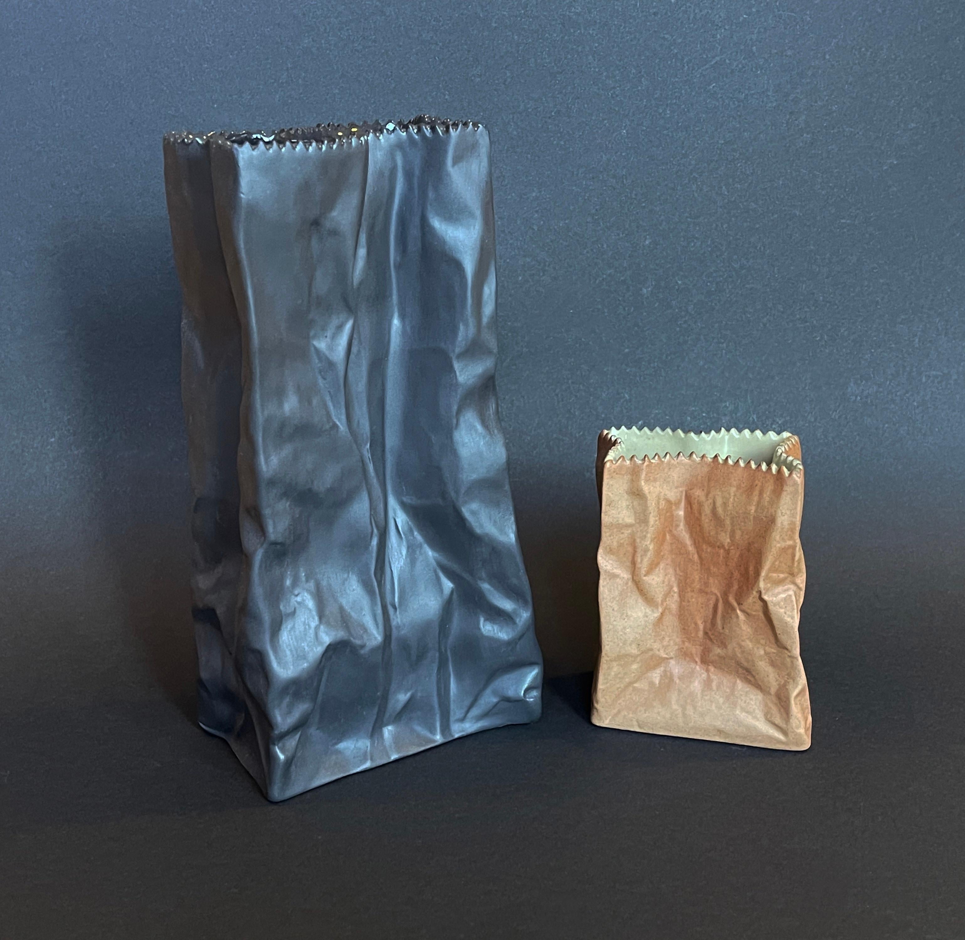 Design-Vintage-Klassiker von Tapio für Rosenthal, Deutschland.
Satz von 2 so genannten ''Paper Bag''-Vasen, die braune, 1977 ca..
Sie hat eine grob strukturierte braune Papiertütenoberfläche und eine graue Innenseite.
Die schwarze Vase ist in dieser