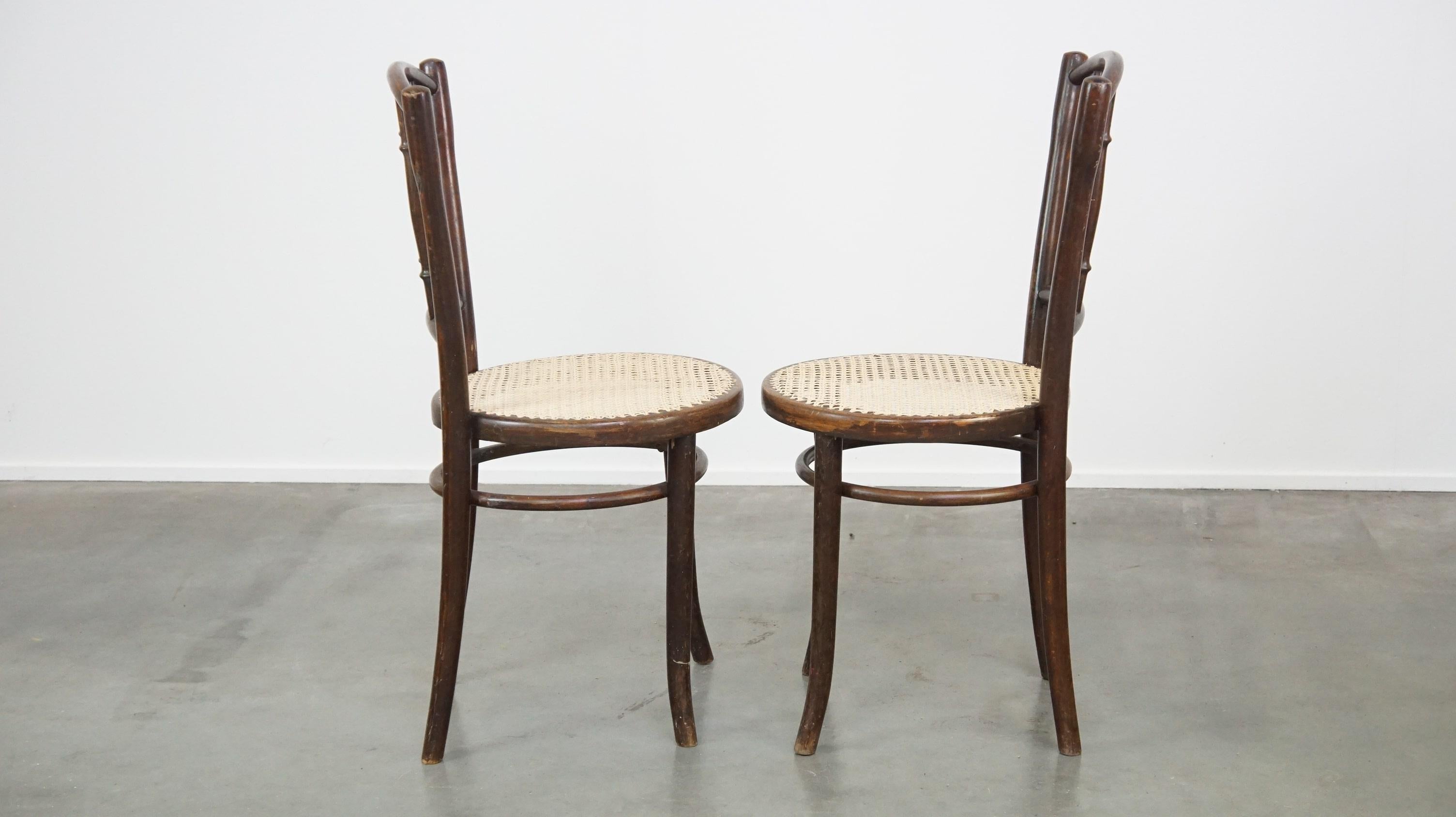 Questo fantastico set di sedie presenta una struttura in legno curvato con seduta e schienale intrecciati. Thonet è il designer e il produttore di queste sedie, come indica il timbro sottostante. Le sedie presentano alcuni segni d'uso dovuti alla