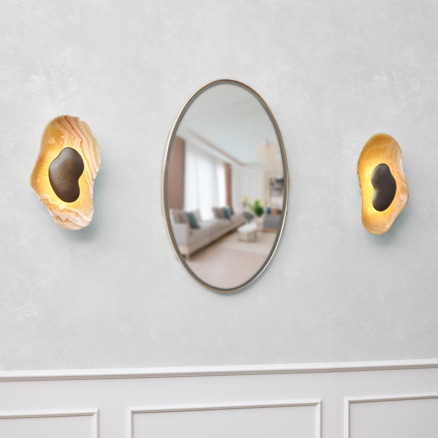 Erleben Sie den exquisiten Charme der Oyster Wall Lamp, ein Duo aus fesselnden Wandleuchten, die für Kunstfertigkeit und Raffinesse stehen. Aus dem seltenen senfgelben Onyx gefertigt, weist jedes Stück eine einzigartige Maserung auf, die dafür