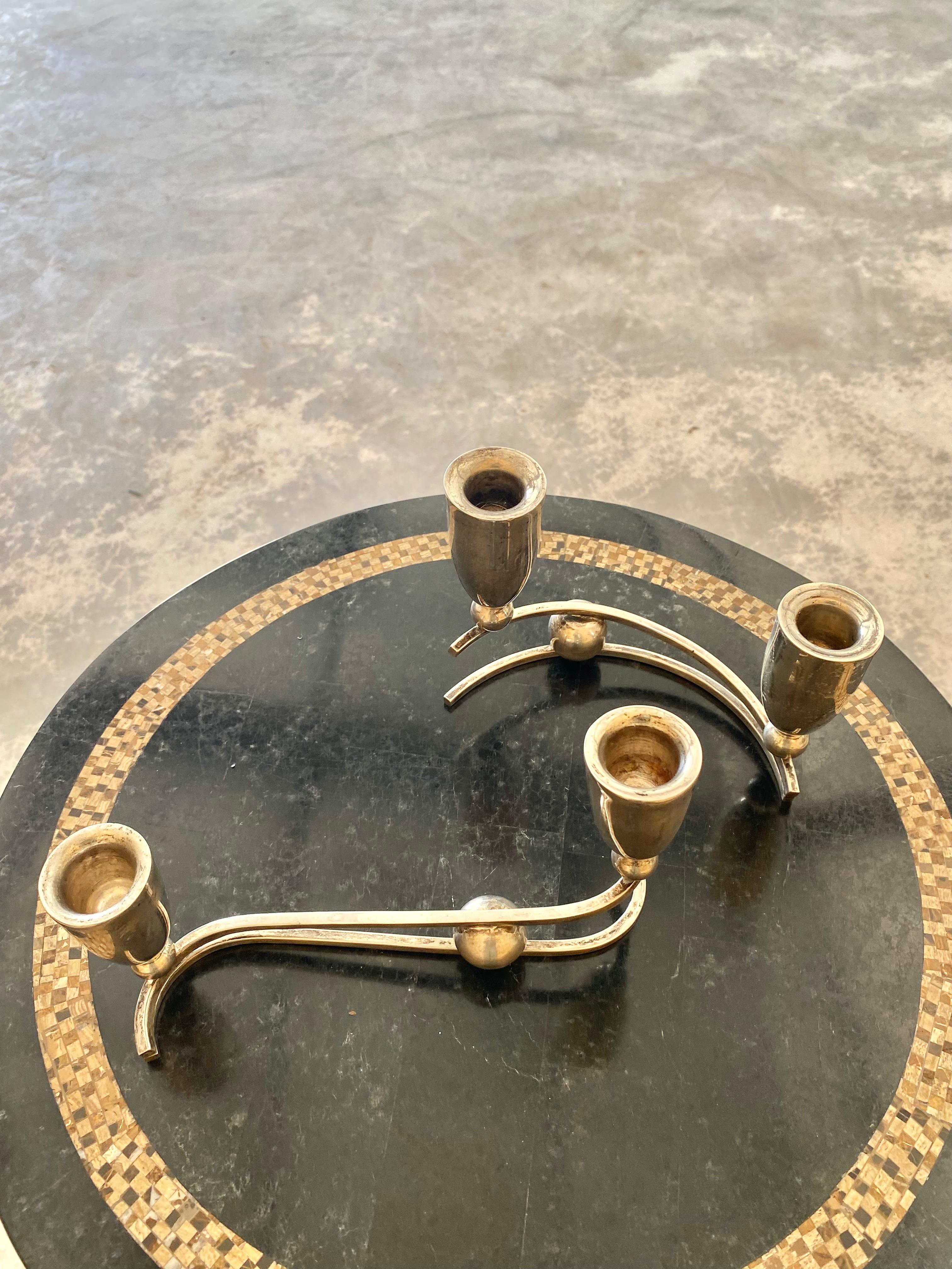 Set di candelabri in argento sterling di P. Lopez G., un artigiano metallurgico di classe mondiale del Mid-Century Modernist.  Realizzato in Messico, circa anni '1950. Il design di ogni pezzo ha una forma curvilinea stilizzata, con candelabri a