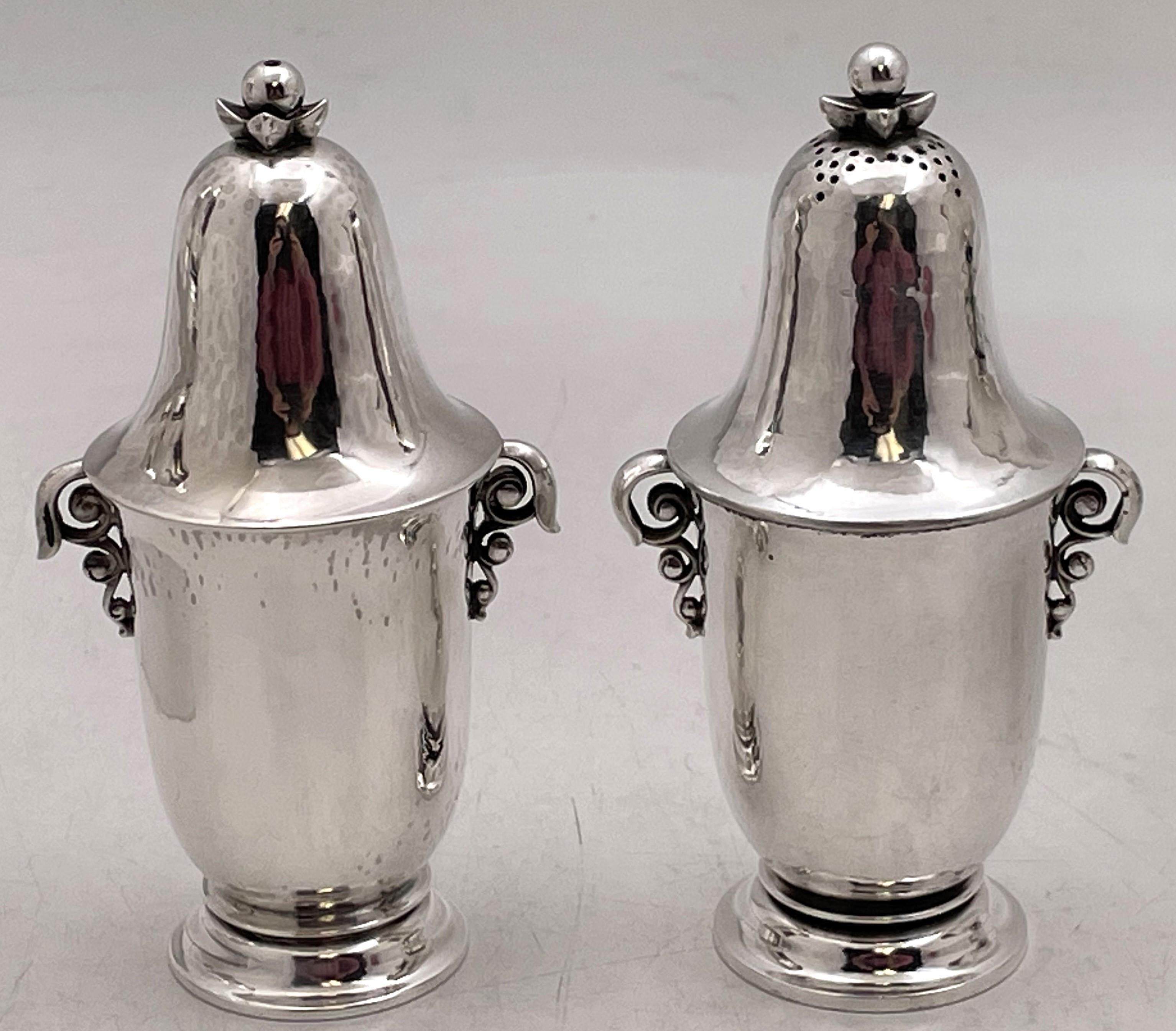 Juego de 2 pares de saleros y pimenteros Georg Jensen de plata de ley, martillados a mano, en el modelo Grape número 363, adornados con estilizados motivos naturales. Miden 5 1/3'' de altura por 2 3/4'' de profundidad y llevan los sellos que se