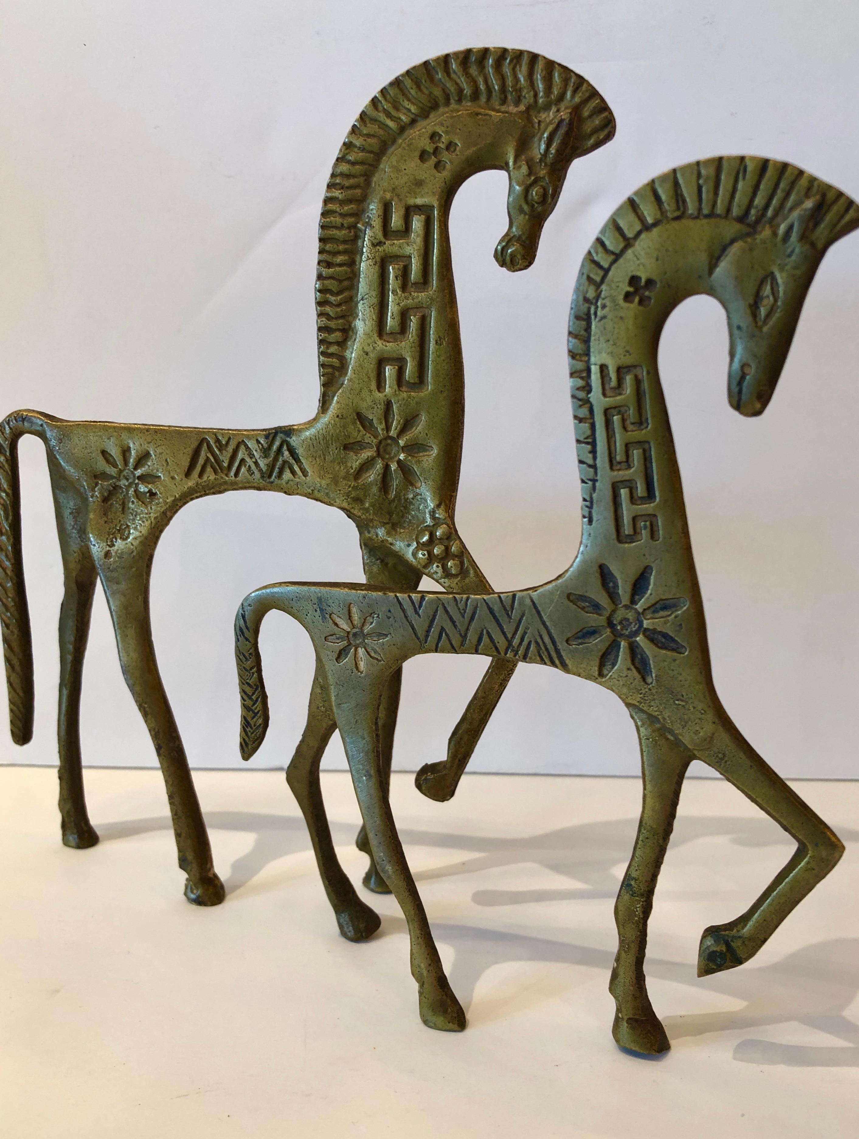 Offered is a set of two Mid-Century Modern Pepe Mendoza style Etruscan patinated carved brass horse sculptures. This set of two Etruscan brass horses is an iconic Mid-Century Modern item of decor with carved Mid-Century Modern details. The set would