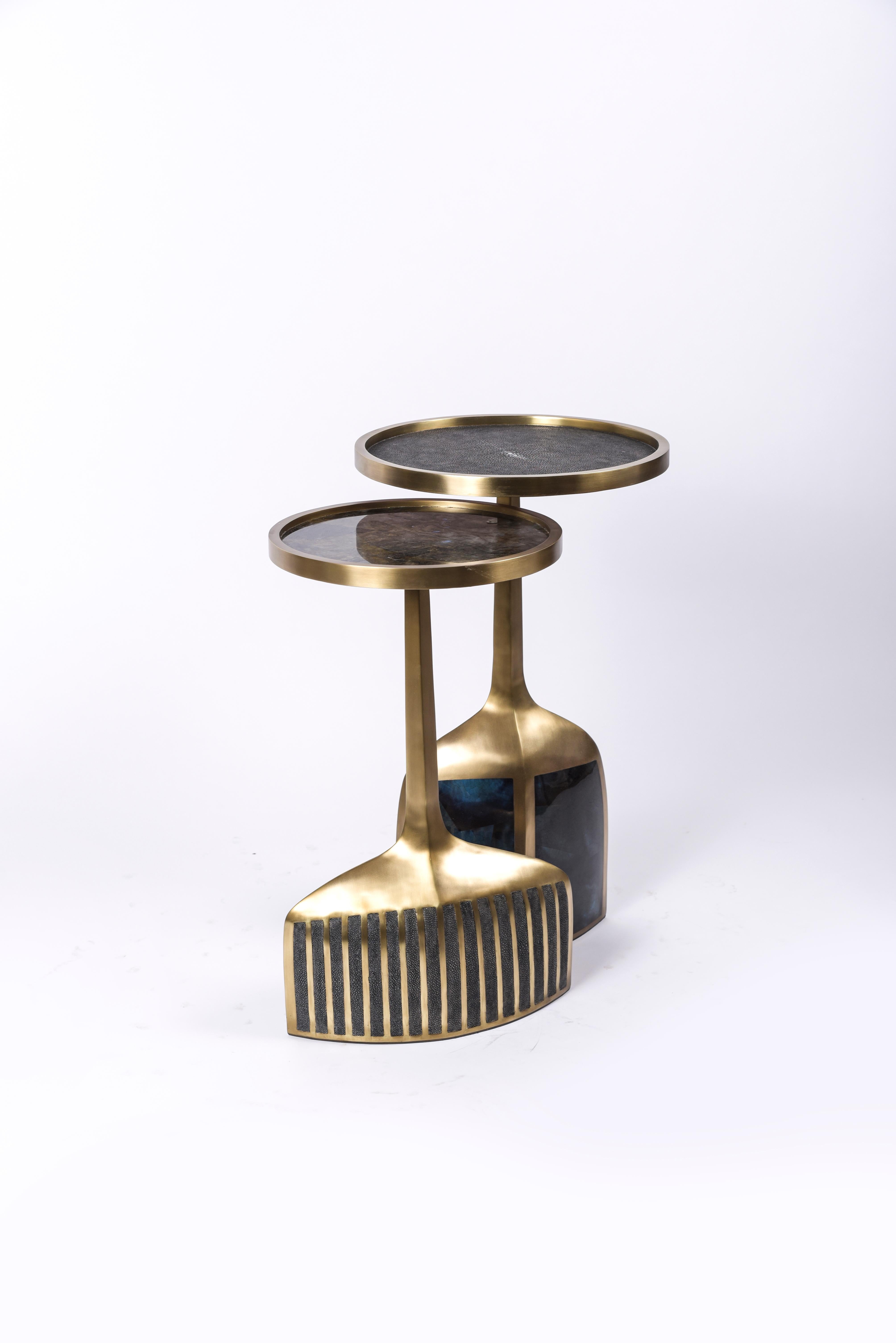 The pedestal side table in small and large are the perfect nesting accent pieces due to their sleek and light aesthetic. The large size is inlaid on the top surface with coal black shagreen, the bottom part a mixture of blue pen shell and bronze