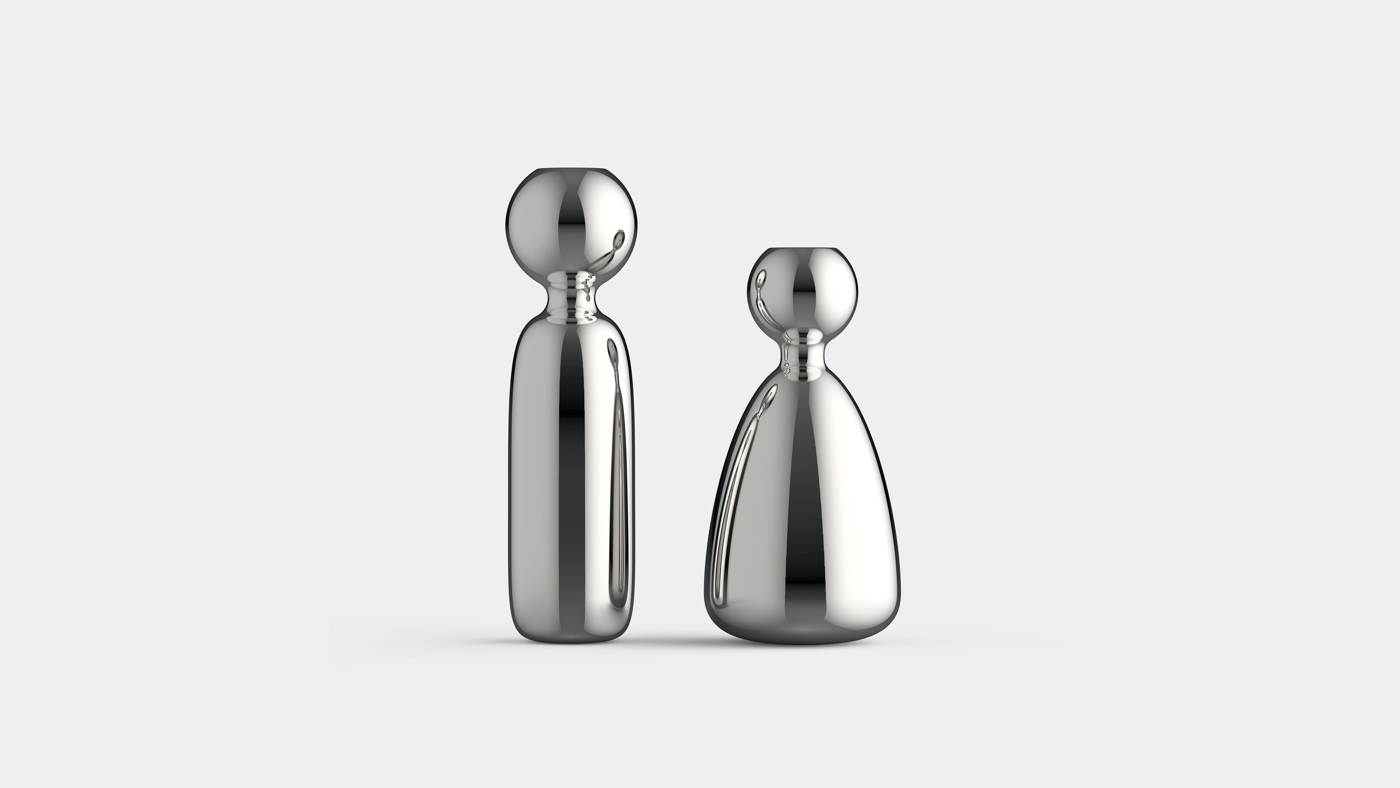 Set di 2 portacandele Personitas di Essesi
Dimensioni: P 6,2 x L 6,2 x H 12,8 cm. 
Materiali: Alluminio lucidato a specchio. 

Essesi è una collezione in crescita che celebra ogni oggetto e il suo posto nell'ambiente. Progettato per elevare un
