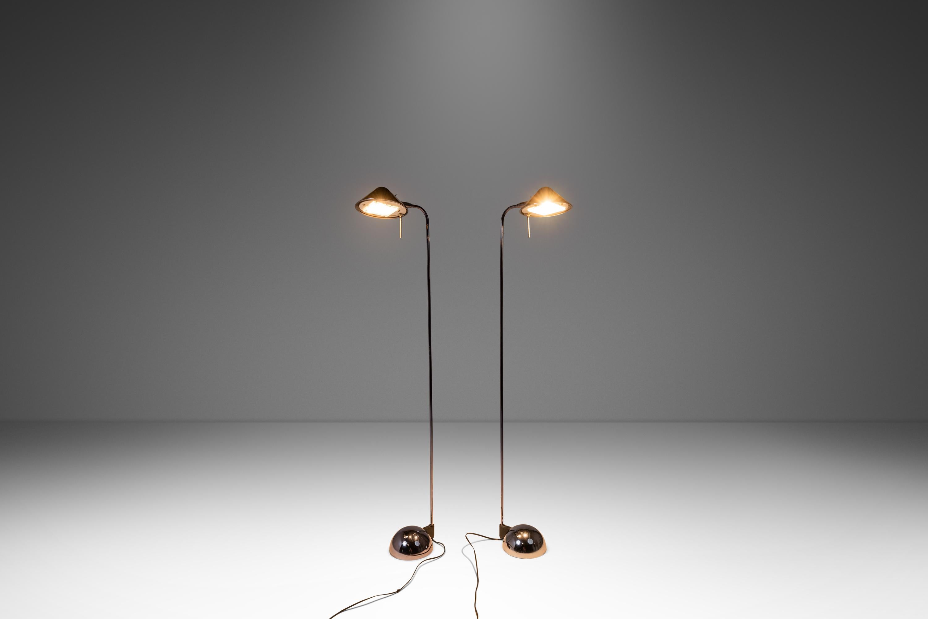 Introducing a true American Modern masterpiece: a rare set of two Post Modern floor lamps designed by the renowned Robert Sonneman for George Kovacs. Constructed from steel with a sultry midnight chrome finish these exceptional floor lamps swivel up