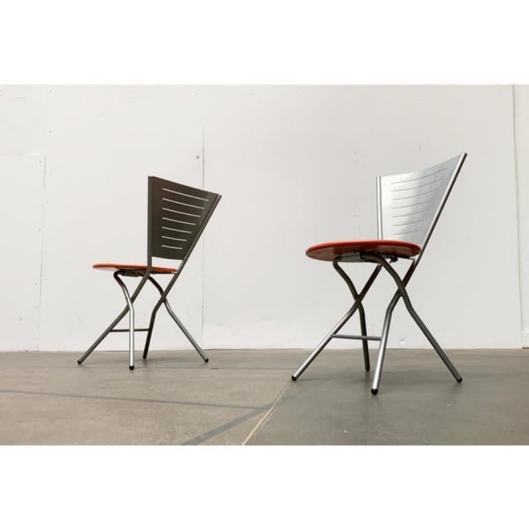 Folding chairs in postmodern design language based on a design by Swedish designer Rutger Andersson.

The design is dominated by distinctive shapes such as circle and triangle. The backrest is concave in shape and flares out towards the top. The