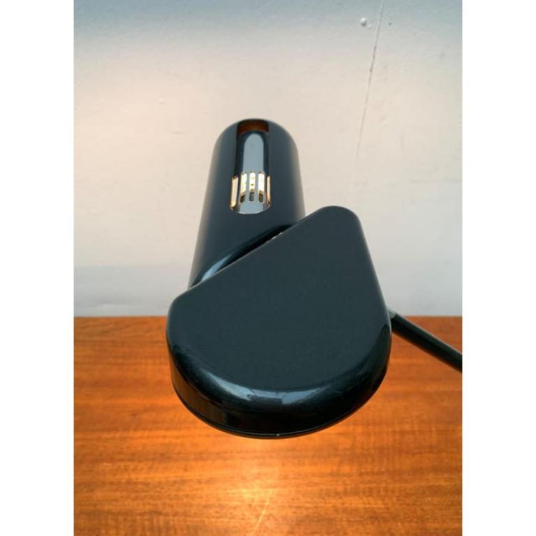 Postmodern table lights from the Italian manufacturer Arteluce according to a draft by Bruno Gecchelin from the late 1970s.

This design convinces with its technical design language and details. The strong inclination of the shaft is striking. The