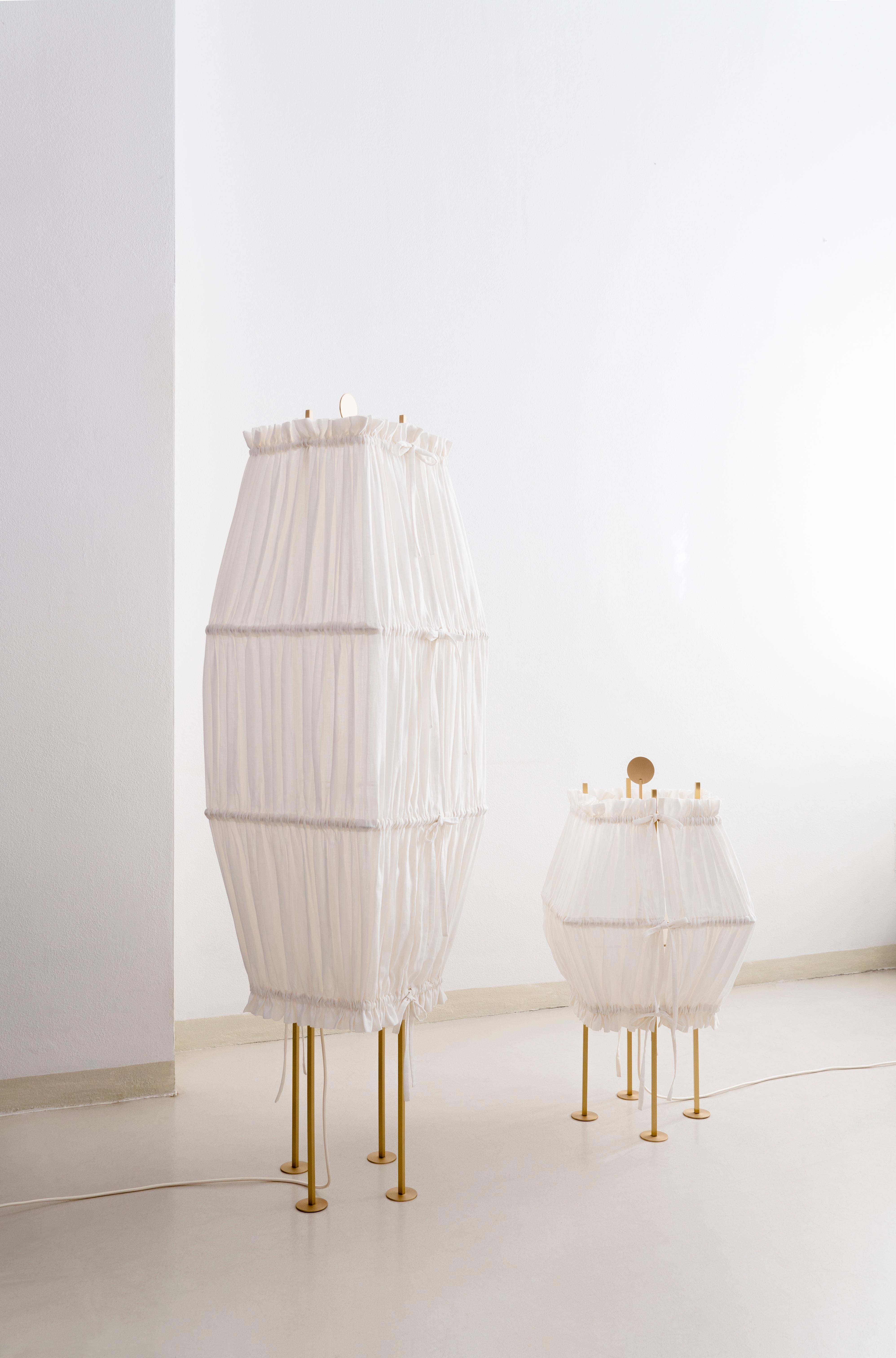 Set of 2 Presenza floor lamps by Agustina Bottoni.
Materials: hemp fabric (GOTS organic certification), satin-finish solid brass, LED lighting
Dimensions: W 42 x D 42 x H 150 cm (large) and W 42 x D 42 x H 75 cm (medium).

PRESENZA
A pair of