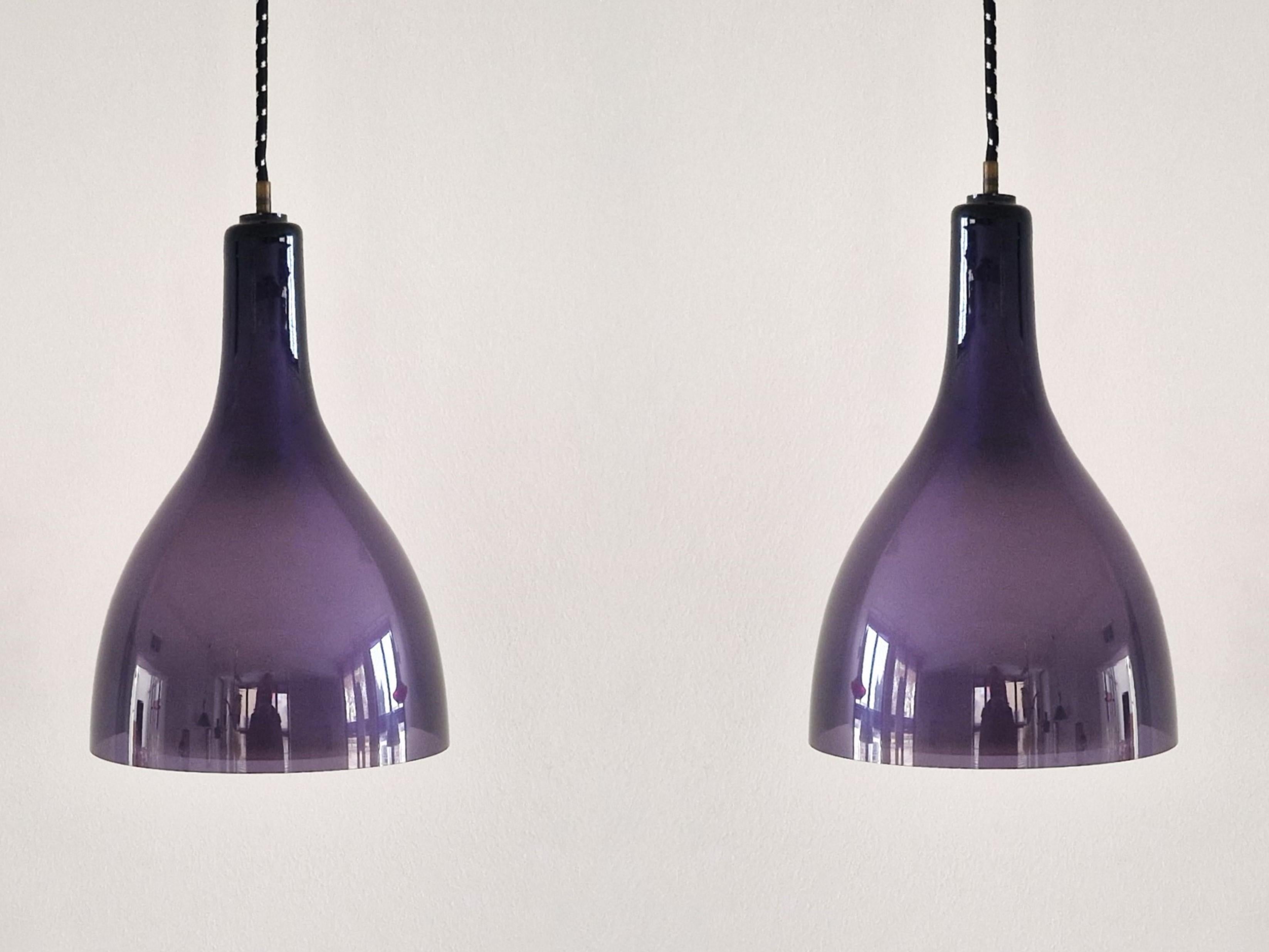 These beautiful and elegant pendant lamps are from the 1960's or 1970's. The lamps have a clear purple glass exterior shade and a smaller opaline white interior shade. They give a good and clear downwards light and a very decorative and warm shine