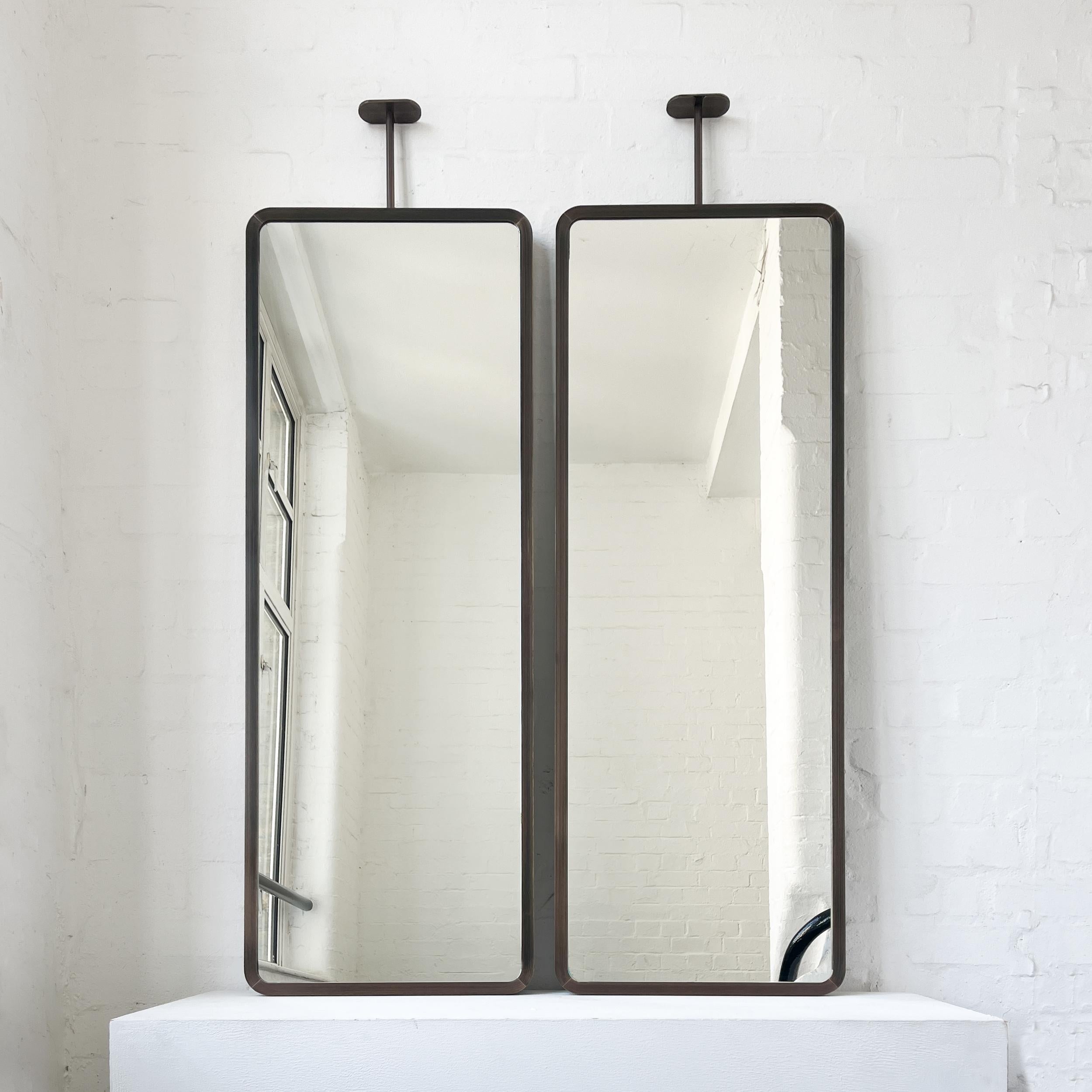 Modern ceiling suspended Quadris™ rectangular mirror with an exquisite  handcrafted brass frame with a bronze patina finish. Available individually or as a set, this mirror is fully customisable to suit the specific requirements of each interior.