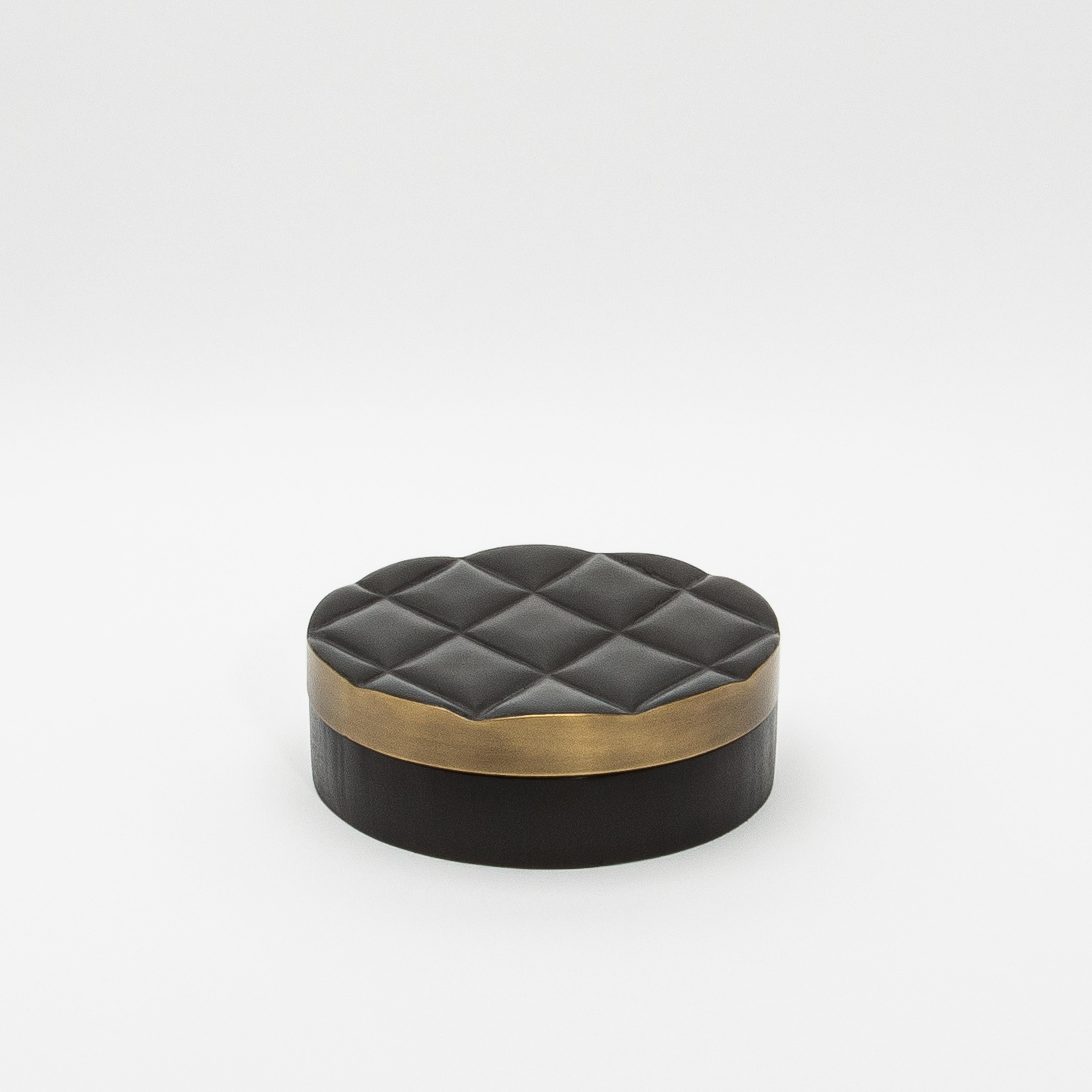 The “Coco” Round Quilted Box set by Kifu Paris is a striking blend of opulence and craftsmanship. Wrapped in luxurious black oak with a stunning quilted design, these round boxes elevate any space with their refined aesthetic. The tactile elegance