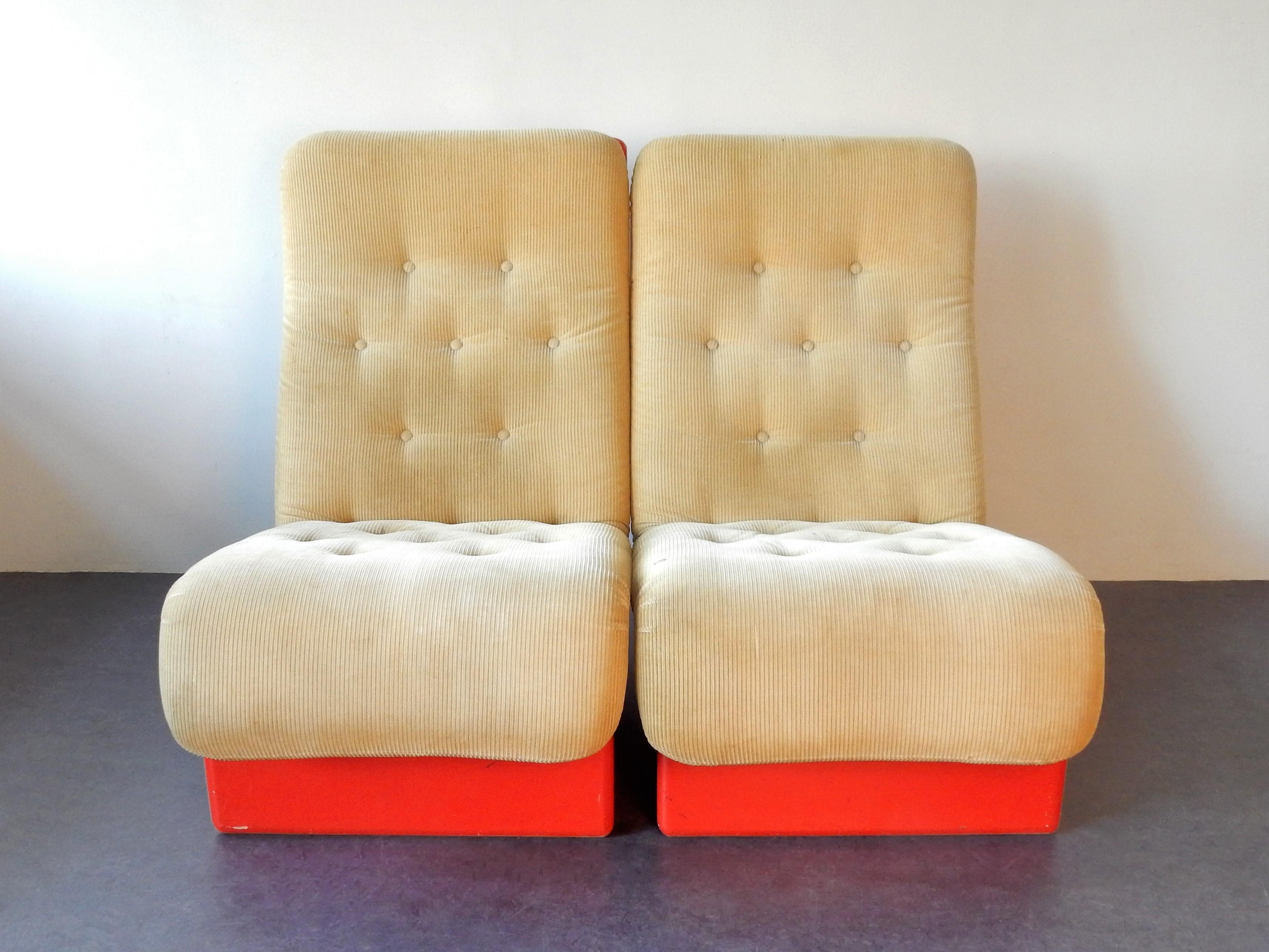 This is a very nice and rare set of 2 lounge chairs made by the Danish manufacturer Cado in the 1960s. The chairs are made of a red lacquered moulded synthetic material with a moulded foam cushion on top that is covered with its original beige