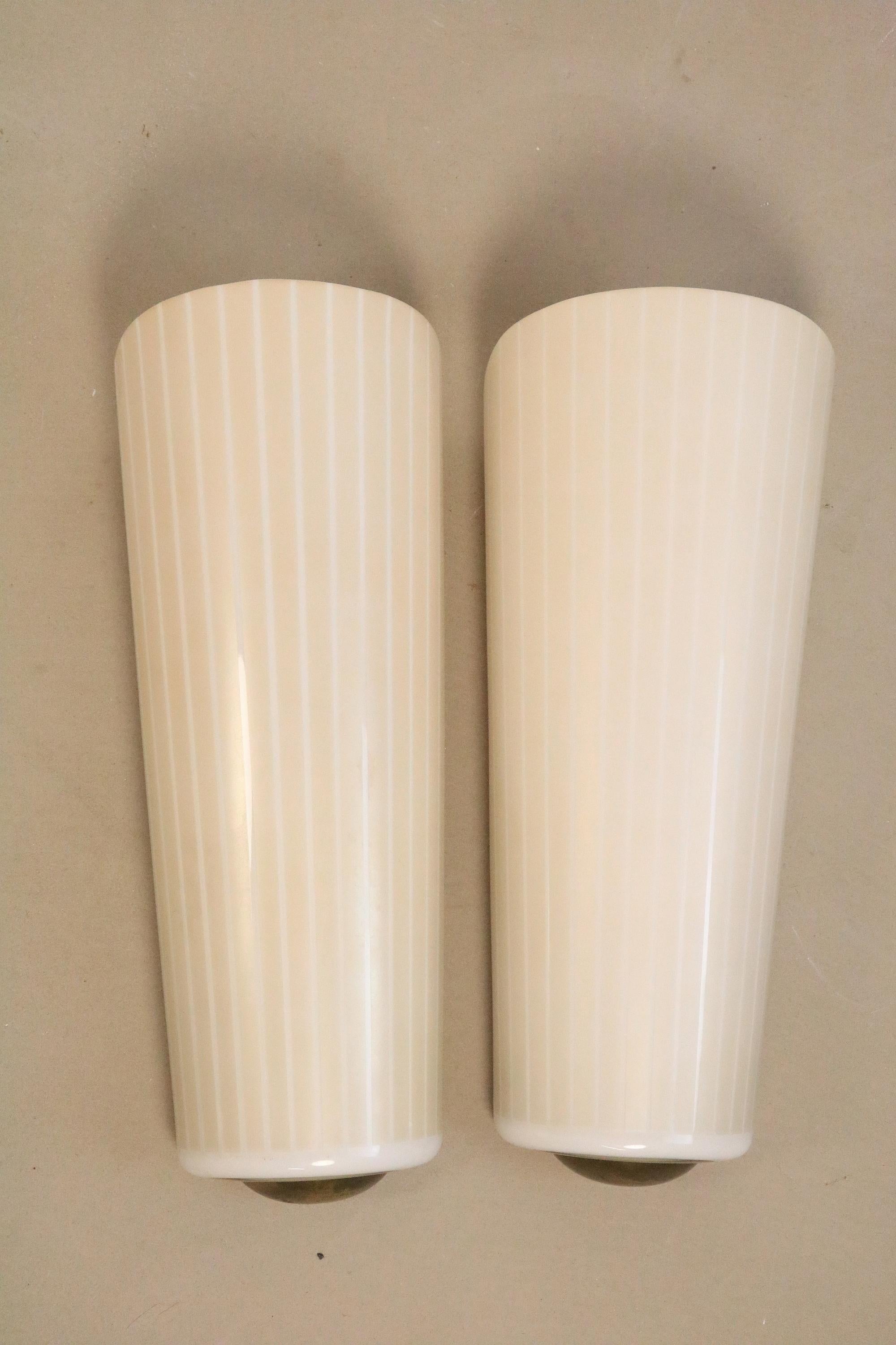 Two wonderful, very rare wall lamps by Peill & Putzler.
Design: Wilhelm Wagenfeld (see last photo).

Fine stripes, champagne colors (One lamp differs slightly in color intensity).

Beautiful brass finial at the bottom.

Height: 37.3 cm /