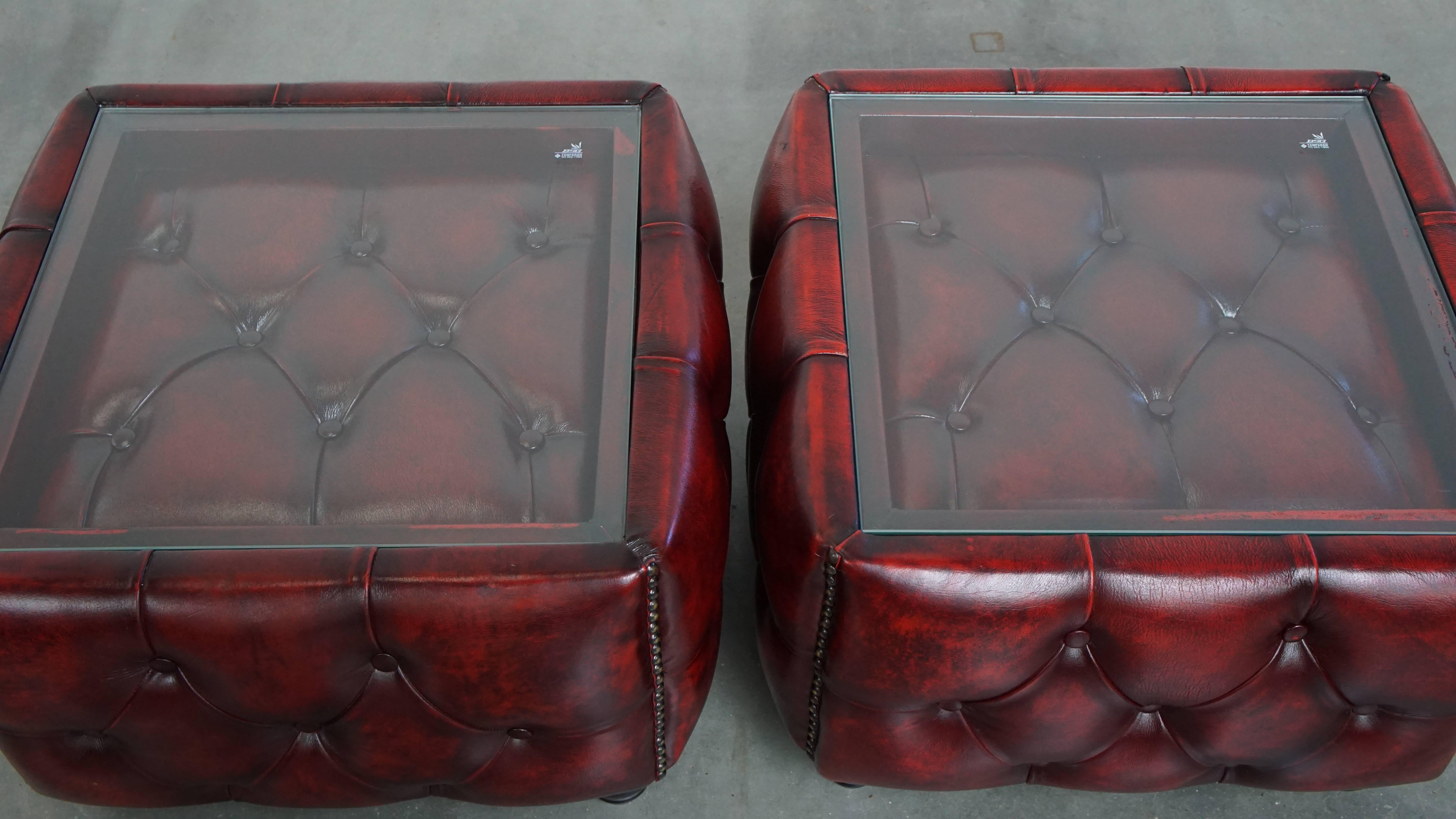 Angeboten wird hier ein Satz von 2 Chesterfield Beistelltischen aus rotem Rindsleder mit Glasplatten. 

Dieses atemberaubende Set von Chesterfield-Tischen ist eine großartige Ergänzung für jeden Liebhaber! Aus echtem Rindsleder gefertigt, sind sie