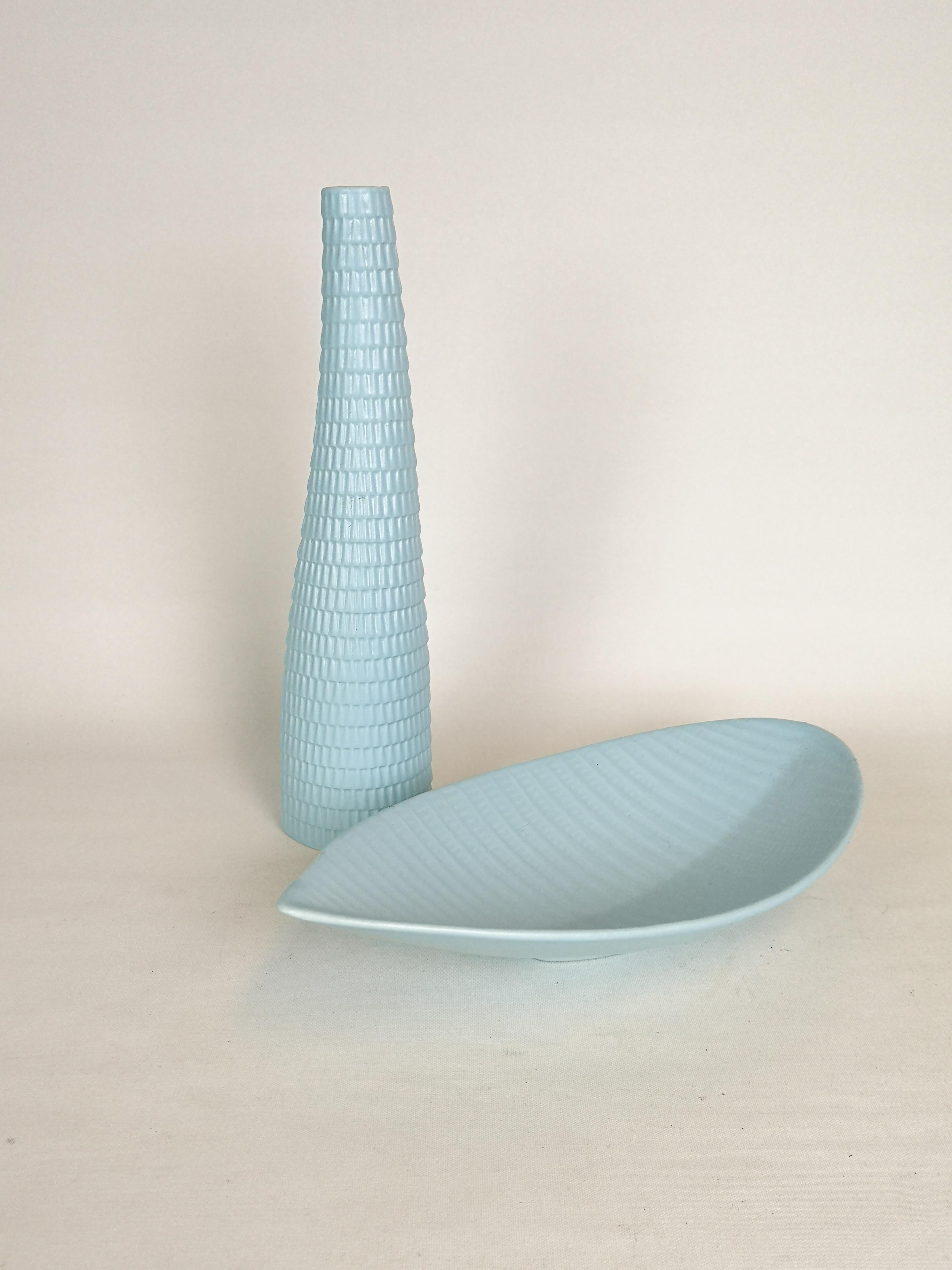 This set of 2 lightblue glazed vase and bowl was produced in Sweden at Gustavsbergs Porcelain Factory. And they were designed by Stig Lindberg. They were meant to look like the skin from a reptile.

Good condition.

Dimensions: The vase H 31 W 9 cm