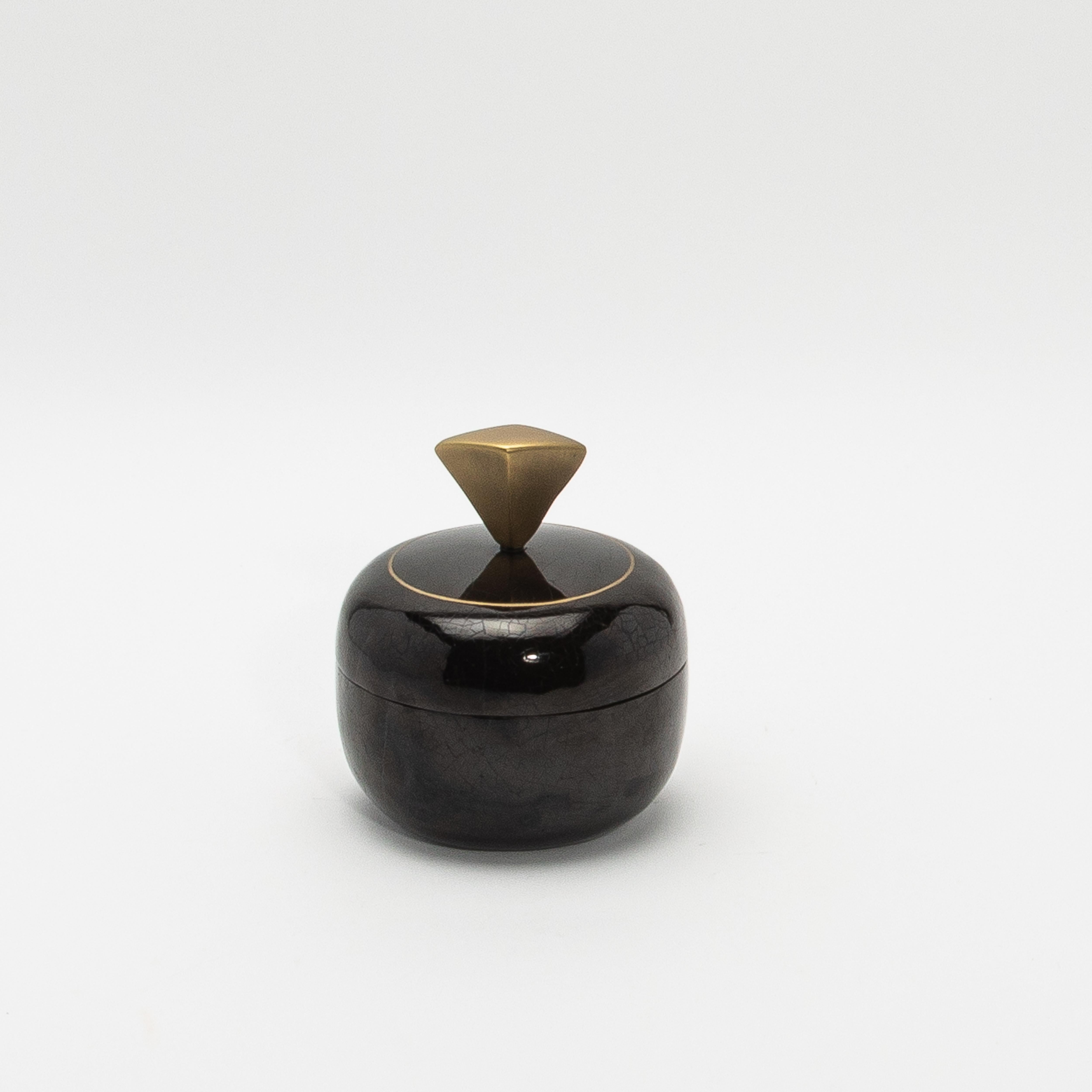 This luxurious set of round boxes by Kifu Paris exemplifies high-end design and artisanal craftsmanship. Meticulously crafted with a veneer of black pen shell, the boxes boast a stunning, high-gloss finish that highlights the intricate patterns and