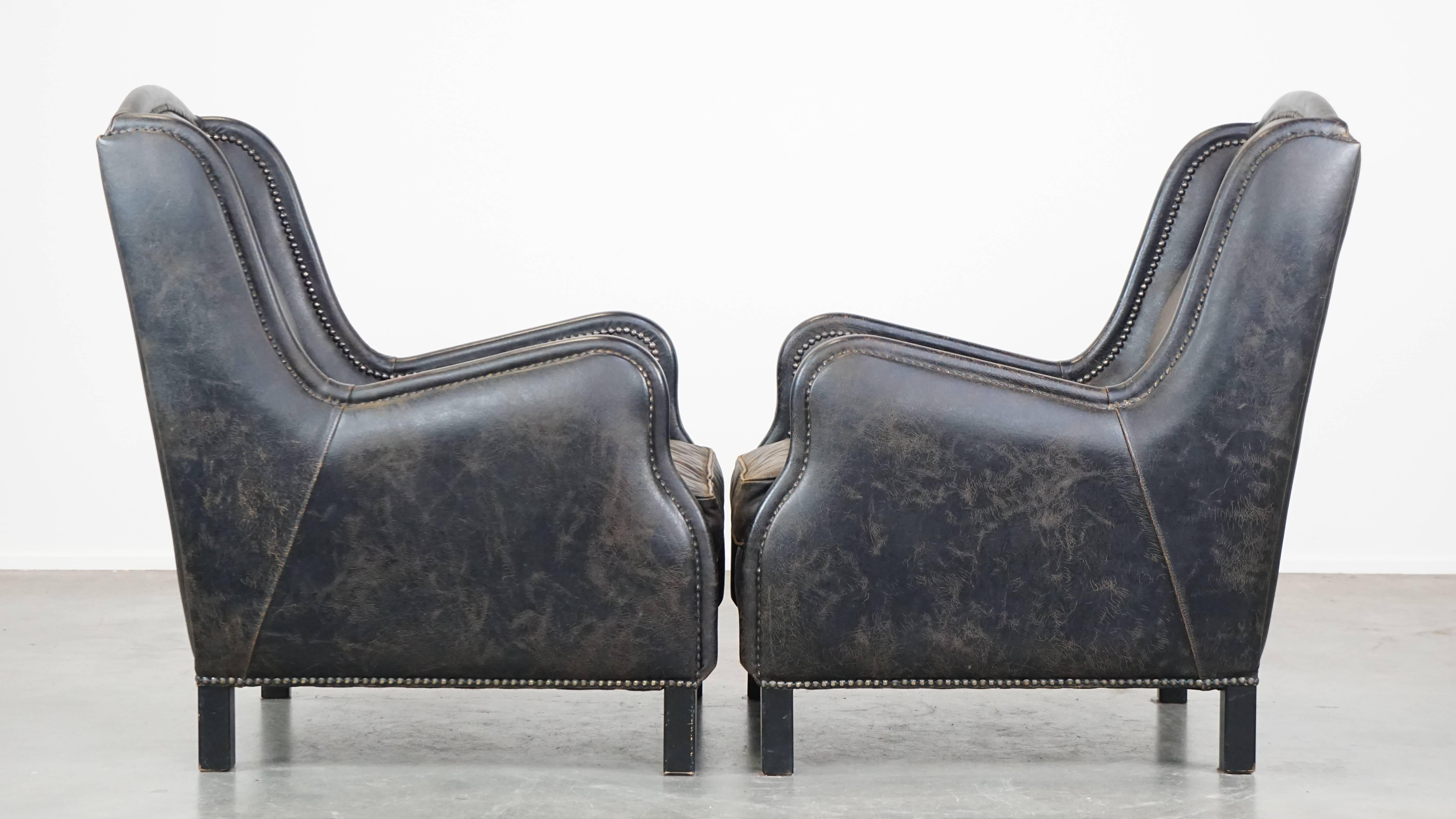 This set of 2 fantastic black cow leather armchairs can easily be placed in nearly any interior. They have a high back and are finished with decorative nails. These armchairs come with removable cushions and offer excellent seating comfort. Due to