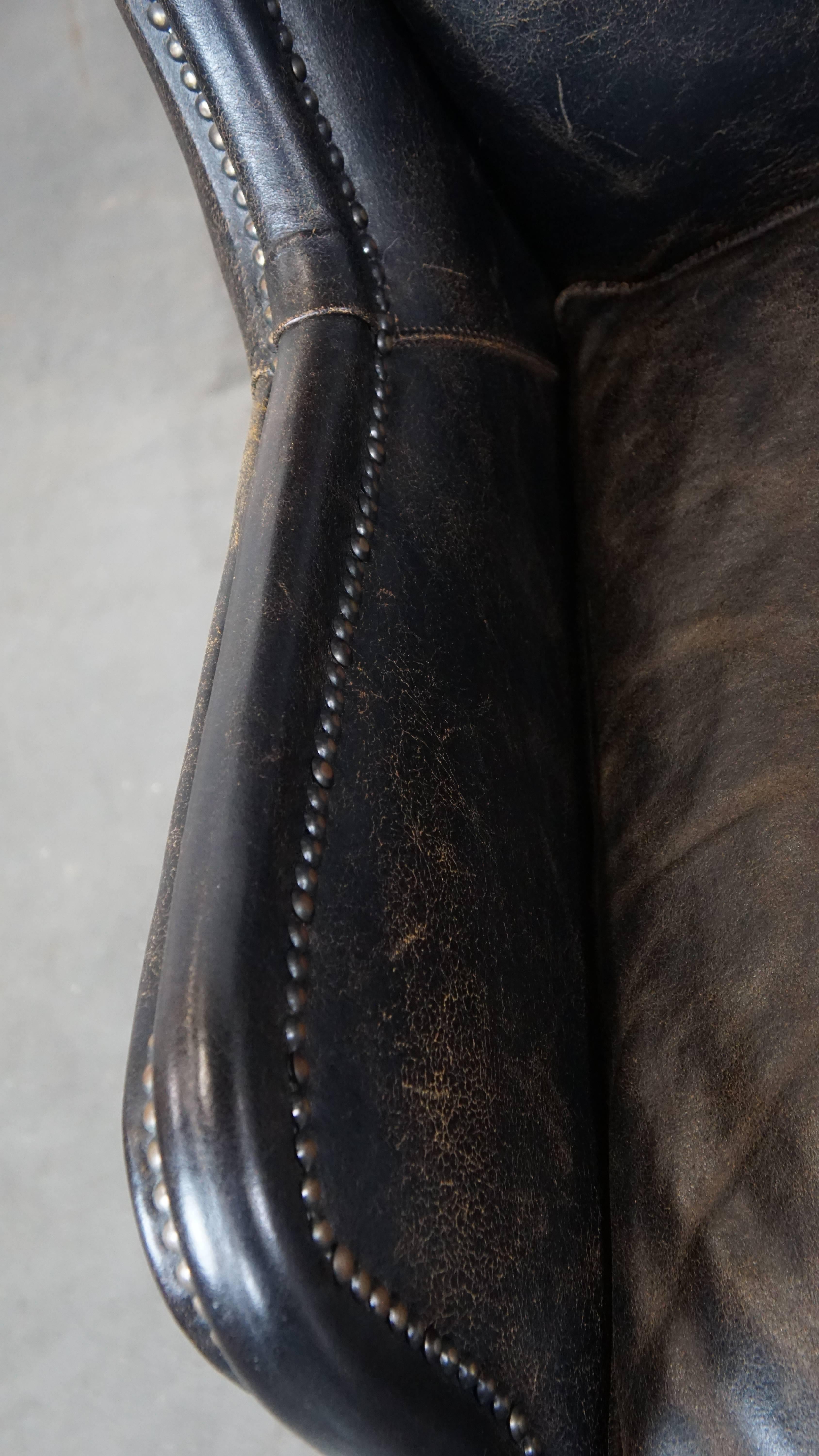 Cowhide Set of 2 rugged black cow leather armchairs with high back, industrial style For Sale