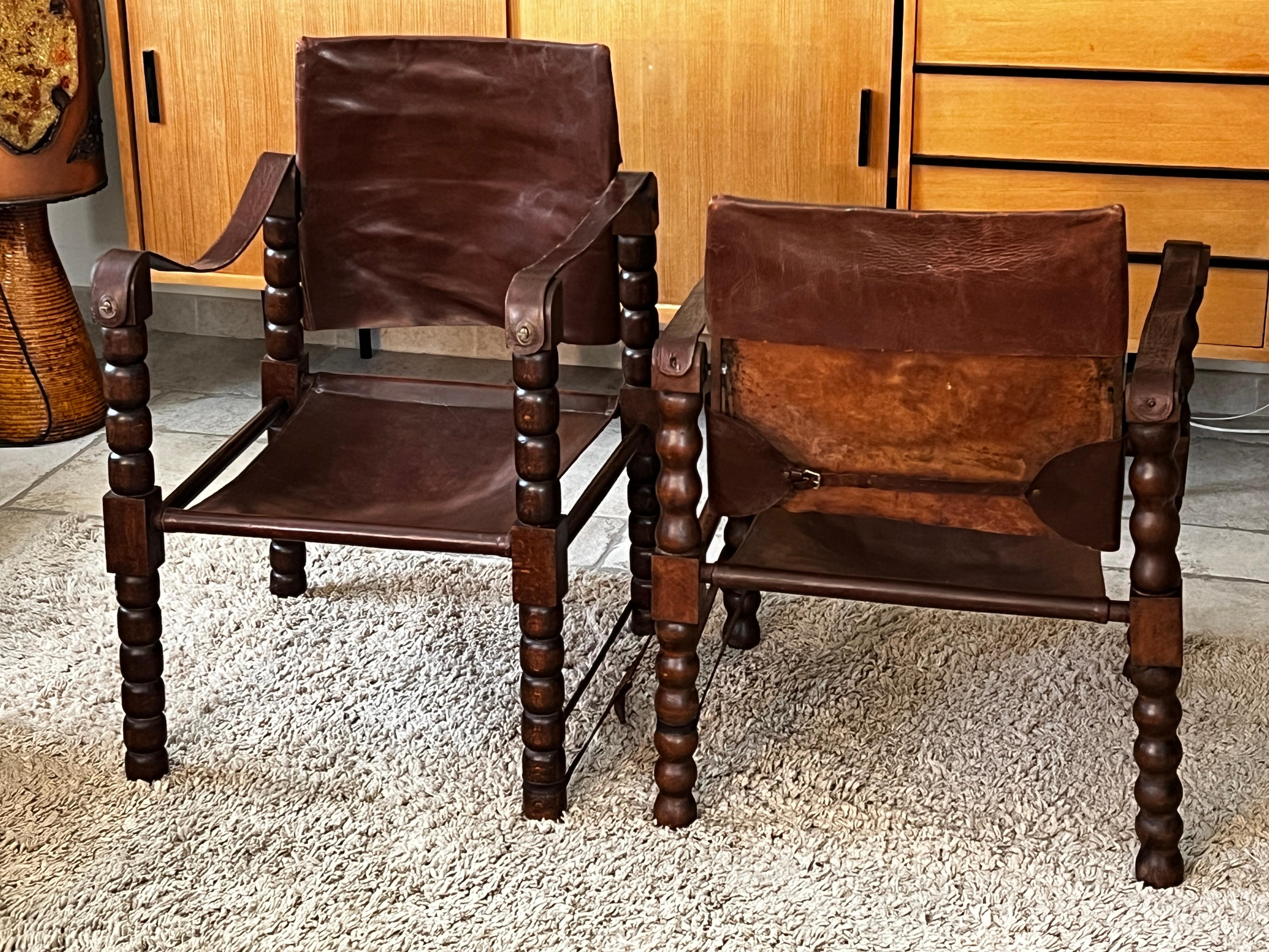 Rare set of 2 safari chairs attributed to Charles Dudouyt 1950.
 Wooden structure, base in the shape of a rosary. Seats and backs in leather 
Seat height : 38 cm 
Good condition.
