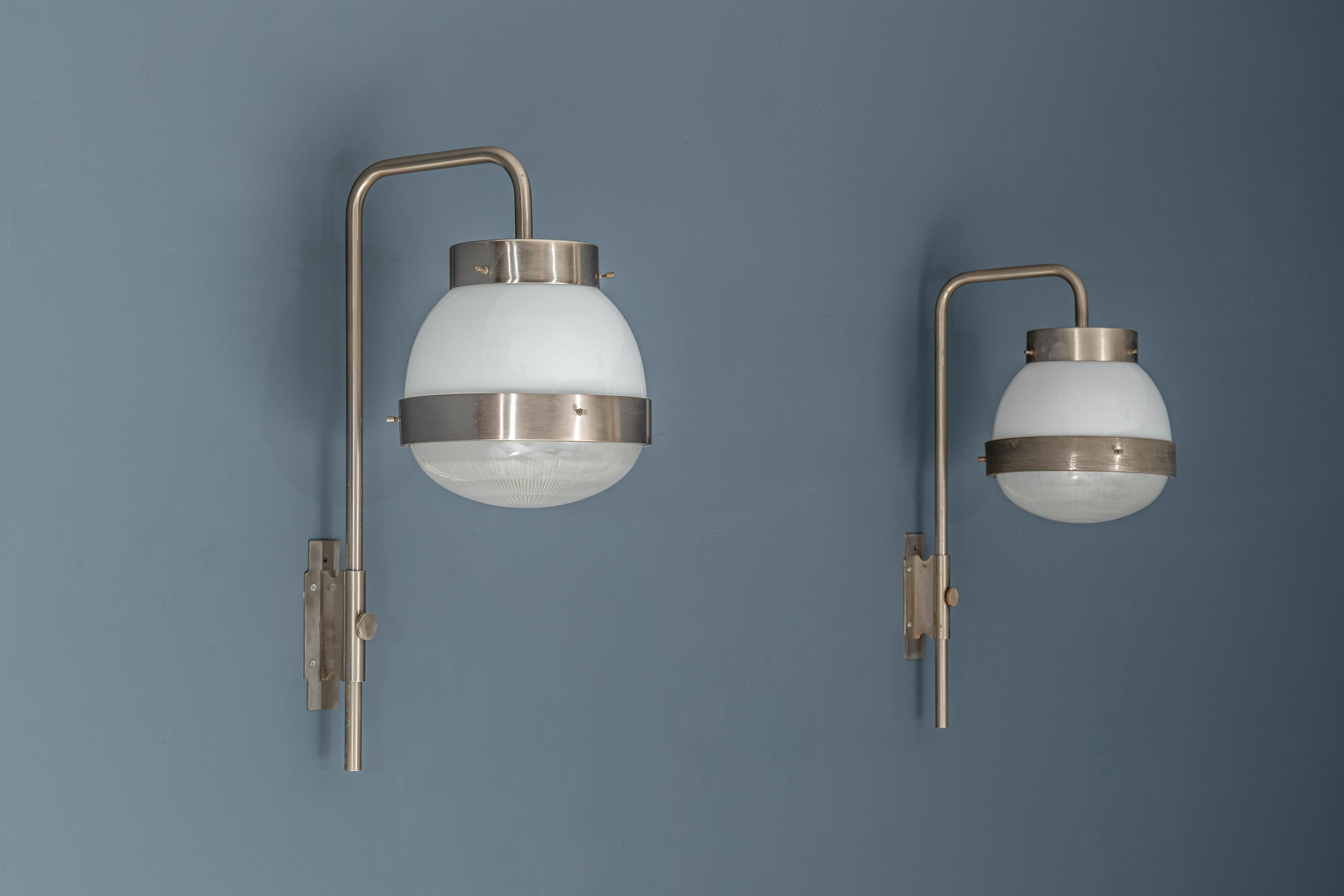 A beautiful pair of the famous Sergio Mazza 'Delta' wall lights for Artemide. Executed in brushed nickelled brass, pressed and glossy opaline glass. A highly adjustable light that can be rotated left or right as well as up and down.

Born in Italy