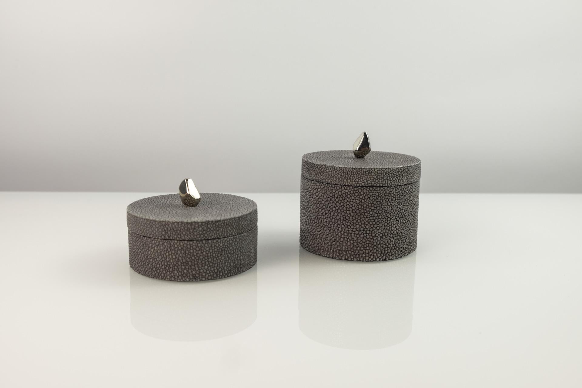 This set of 2 round boxes is made of shagreen.
These boxes have a nickel brass handle. 

They are lined with a black micro suede.

The color of this box is dark grey.

The dimensions of each piece is:
Diam 3.34