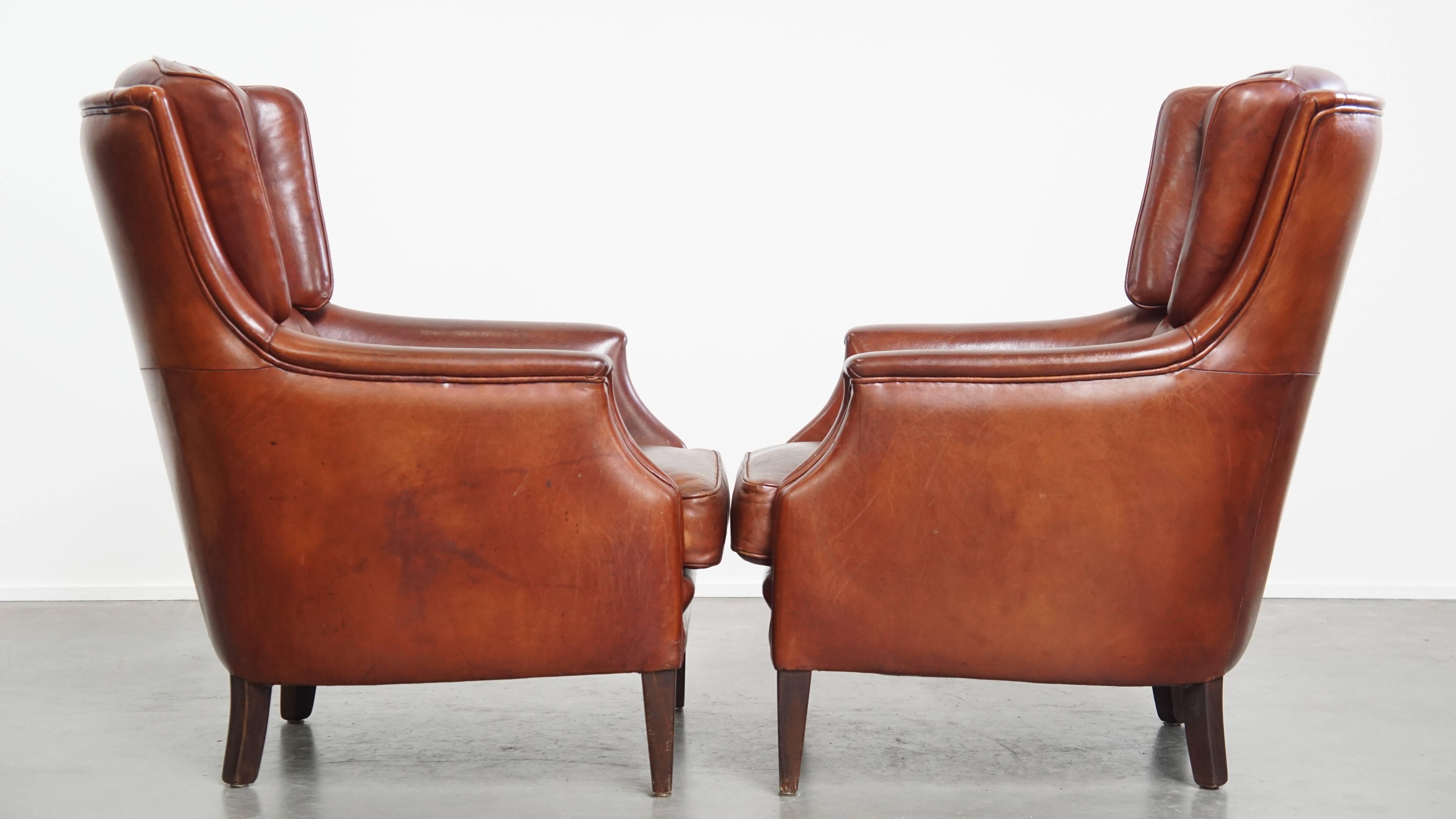 Offered here is this comfortable and characterful set of 2 sheepskin leather Chesterfield armchairs with ottoman. This elegant set of 2 sheepskin leather armchairs with ottoman is crafted from soft sheepskin leather and features refined piping in