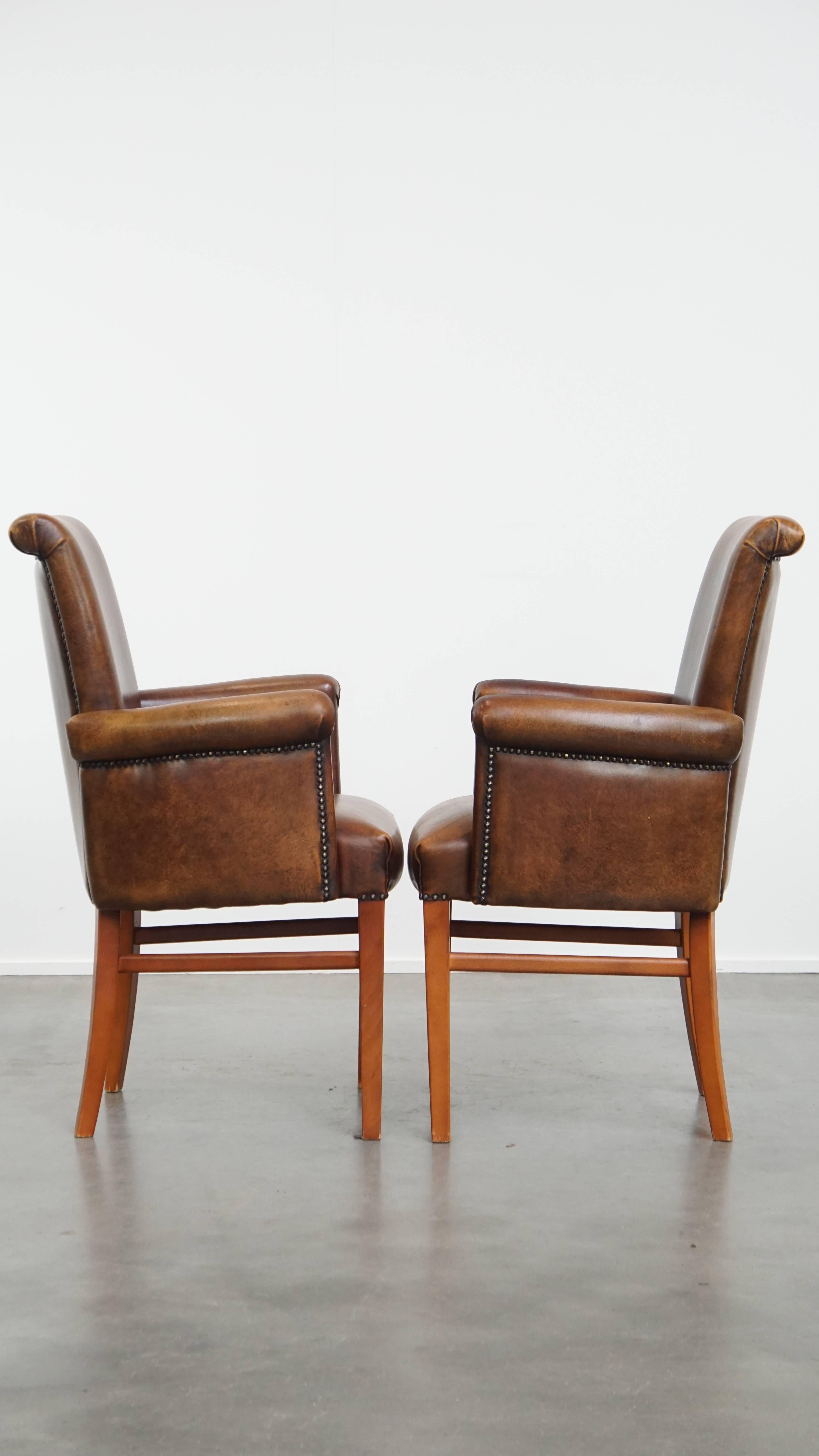 Nous vous proposons cet ensemble de 2 chaises de salle à manger / chaises d'appoint en cuir de mouton avec accoudoirs et une belle couleur chaude.
Avec leur apparence intemporelle et majestueuse et leur couleur riche, cet ensemble de 2 chaises en