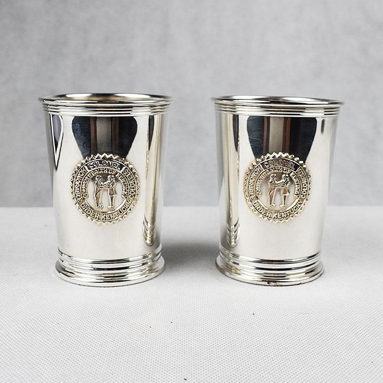 A Classic traditional pair of round electroplated mint julep cups in silver. The front of each cup showcases a seal with the following engraved into the middle. “Honorable Order Kentucky Colonels, Commonwealth Kentucky” Along with two figures